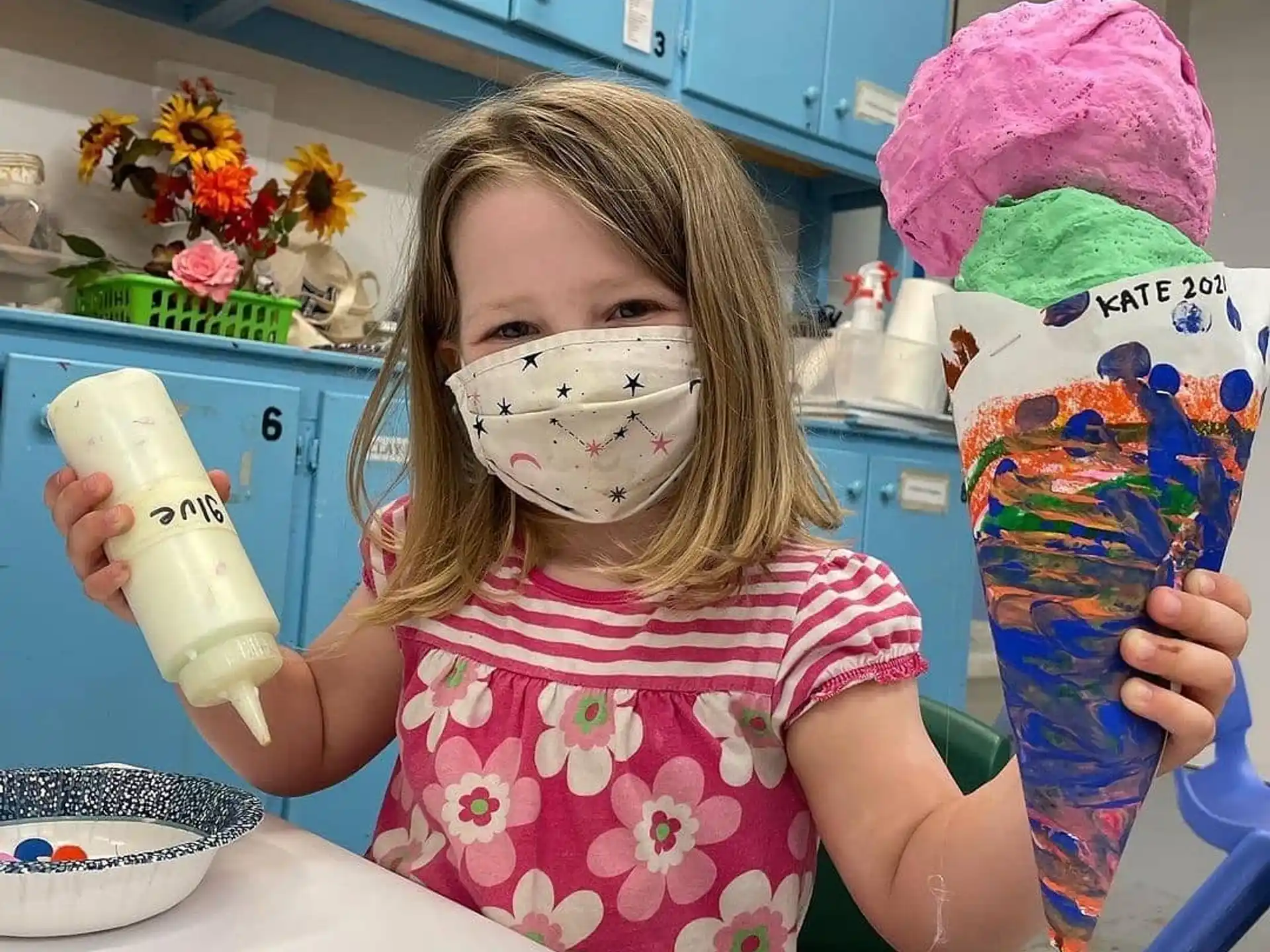 a girl with a paintbrush and paint on her face