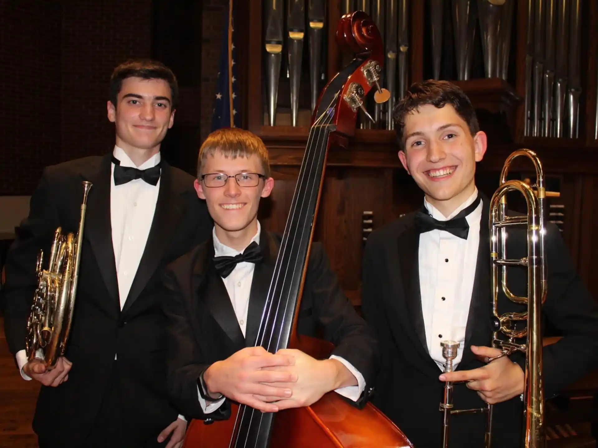 a group of men in suits holding musical instruments