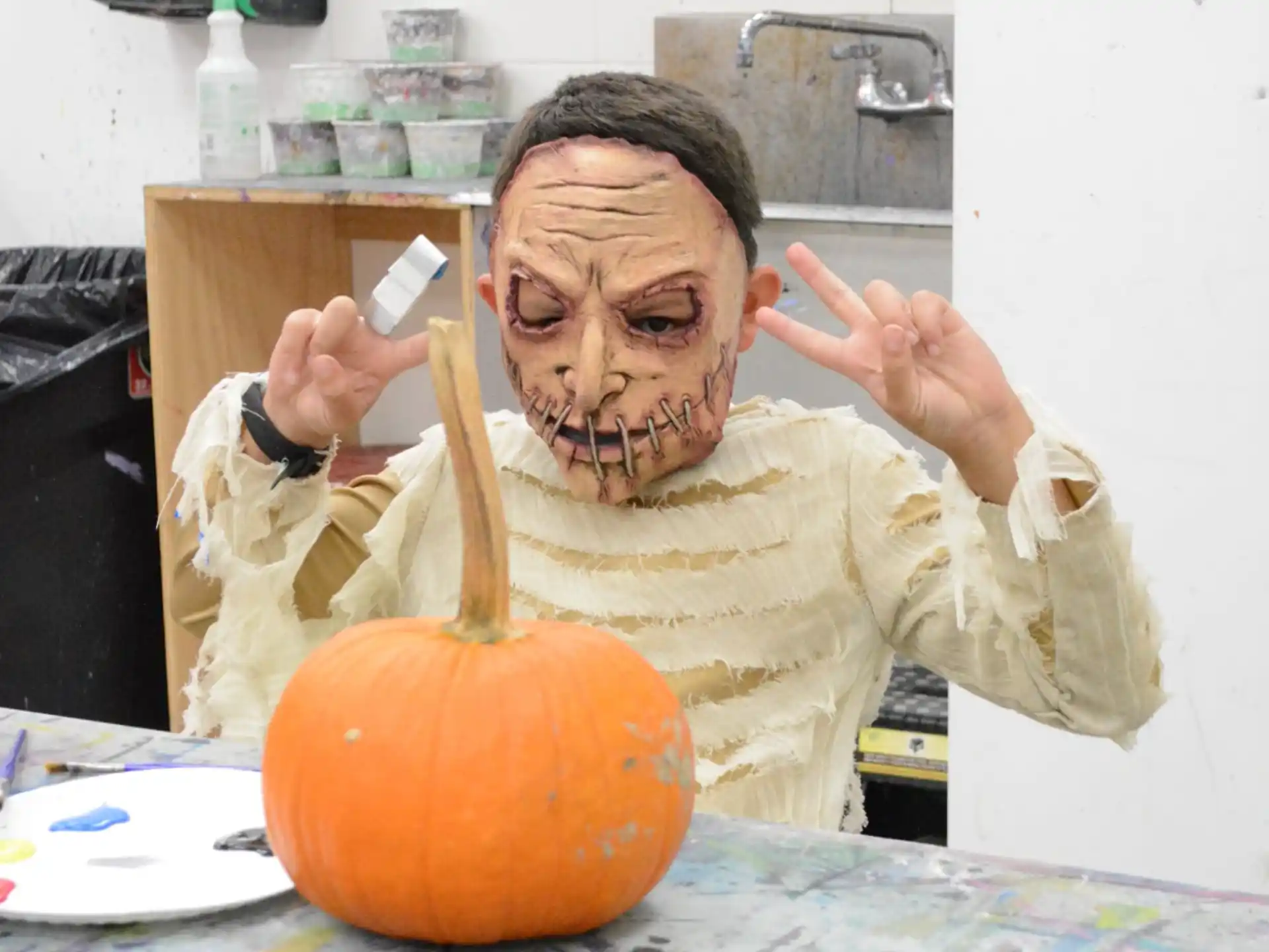 a person with a face painted on a pumpkin