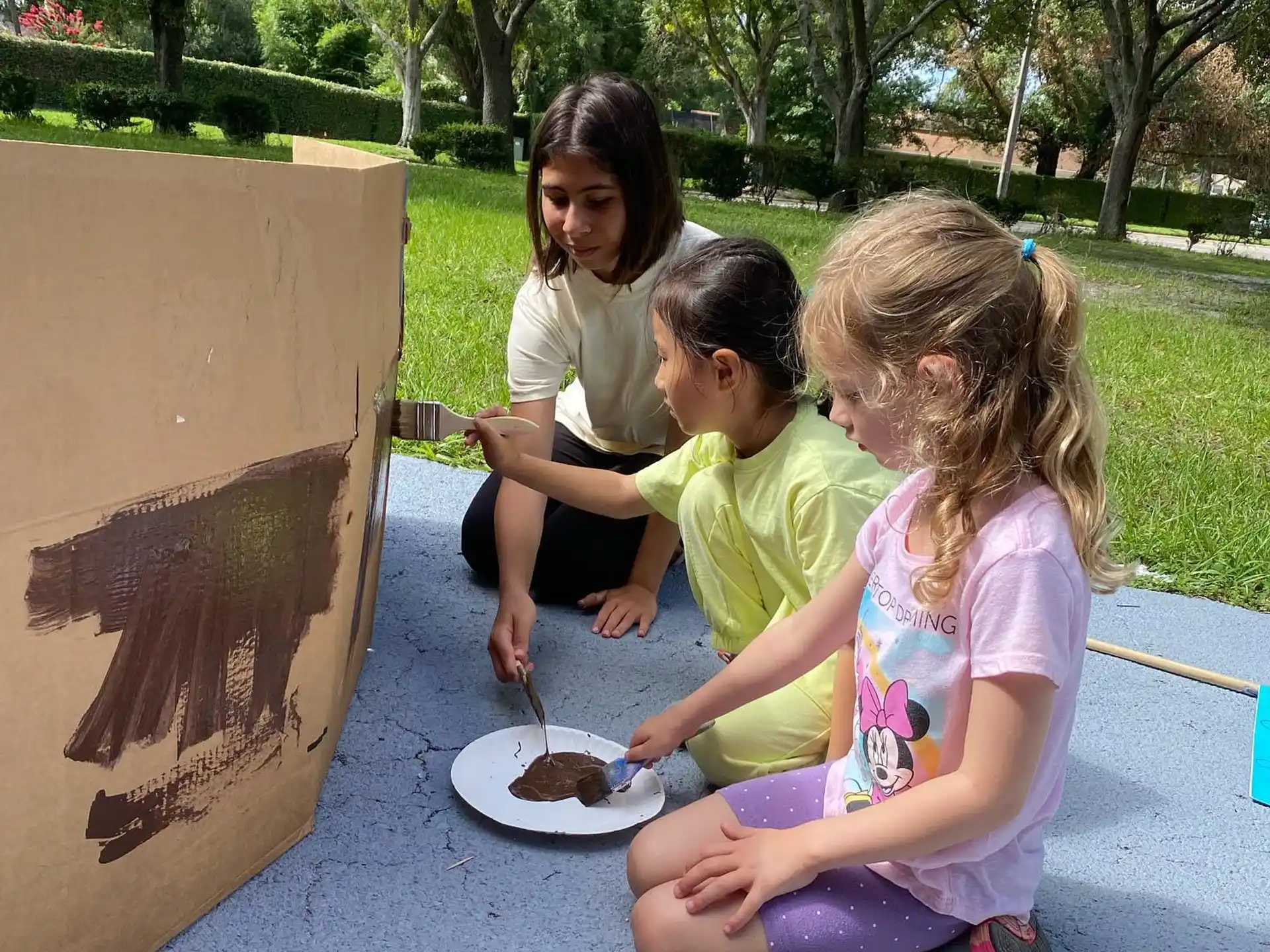 a group of girls sitting on the ground eating food