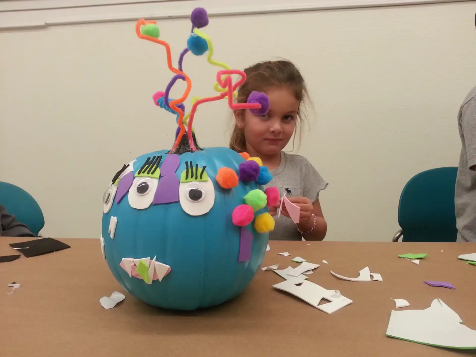 a girl sitting at a table with a large blue and yellow globe