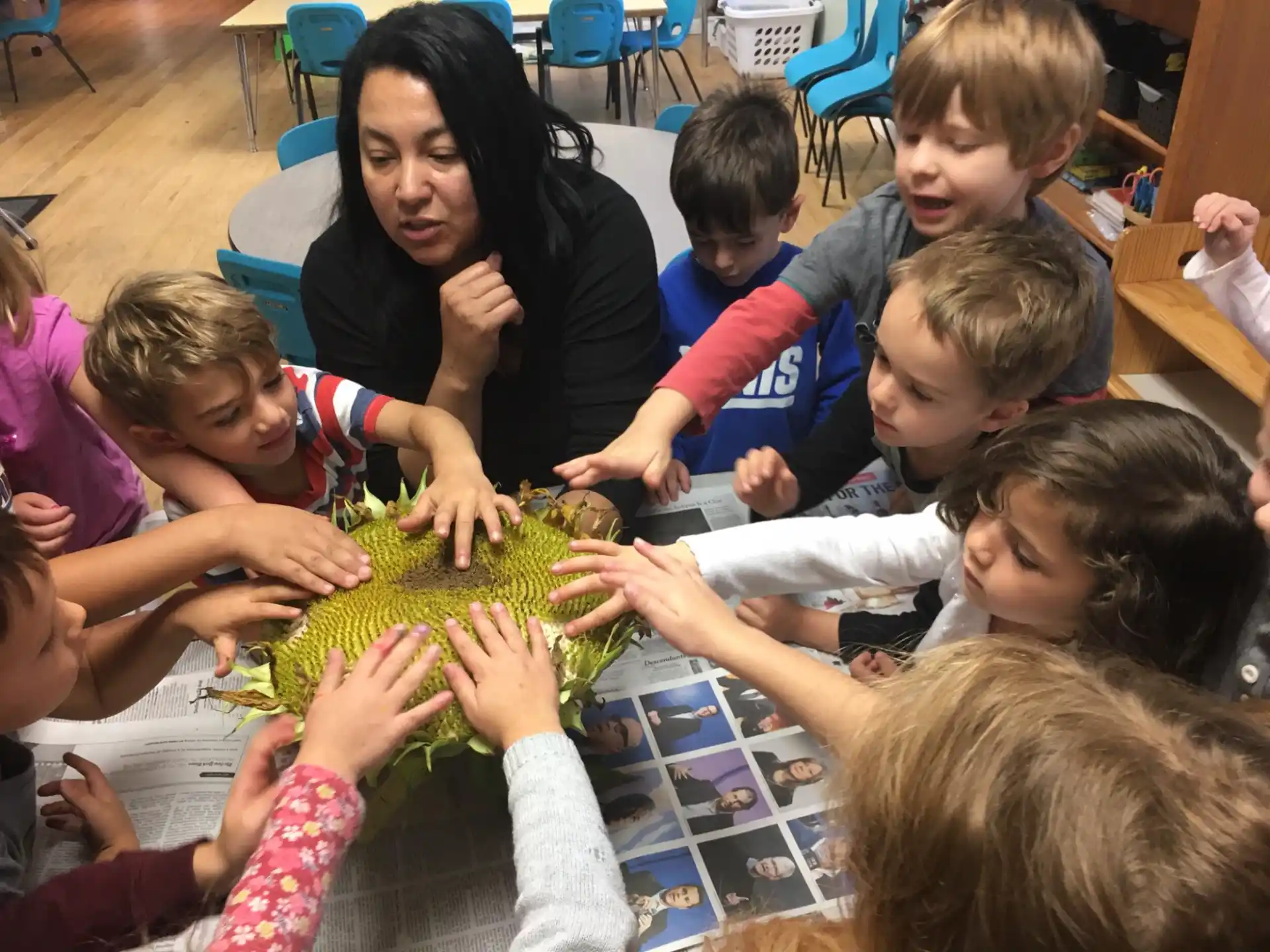 a person teaching children how to use a green plant