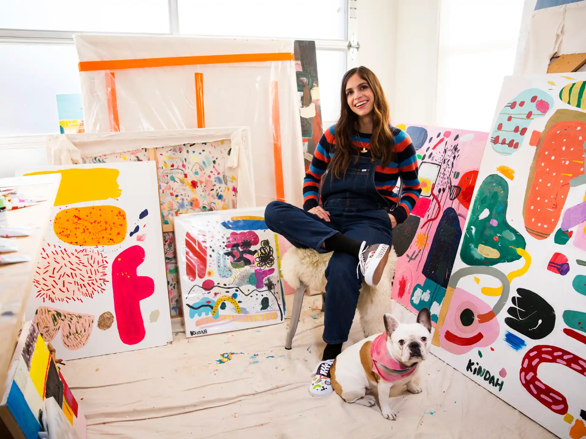 a person sitting on a chair with a dog in front of the