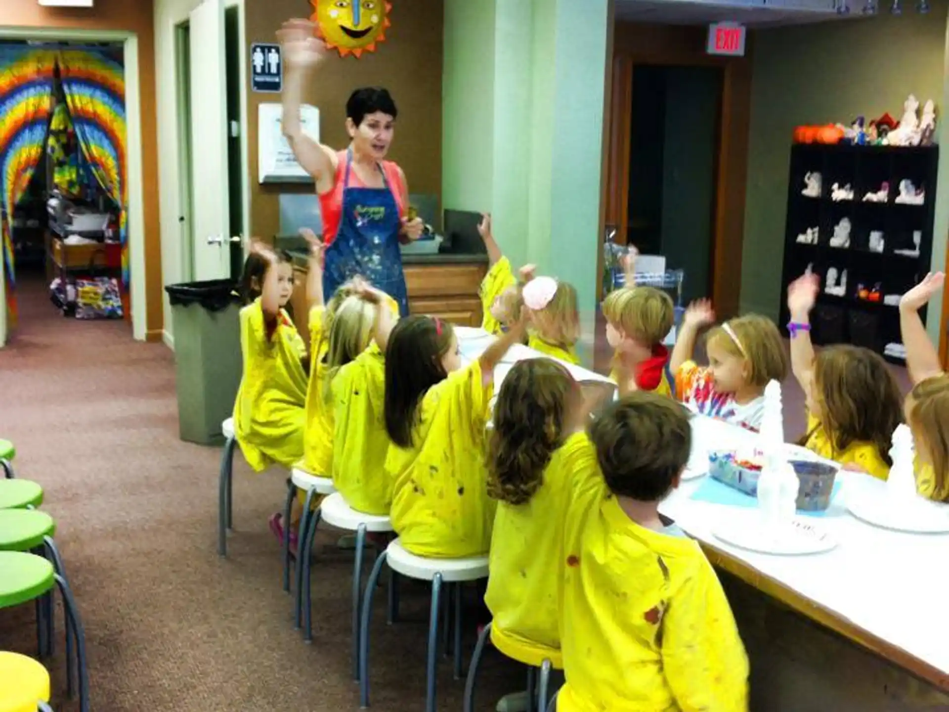 a person standing in front of a group of children sitting at desks