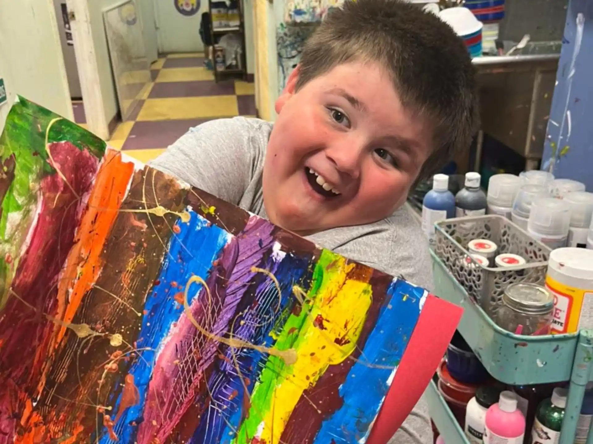 a boy holding a bunch of colorful lollipops