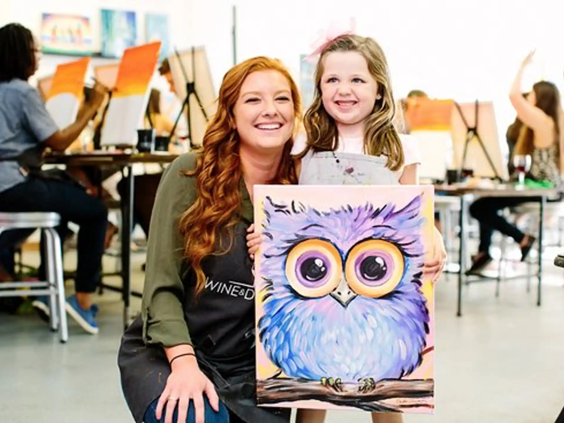 a couple of girls holding a drawing