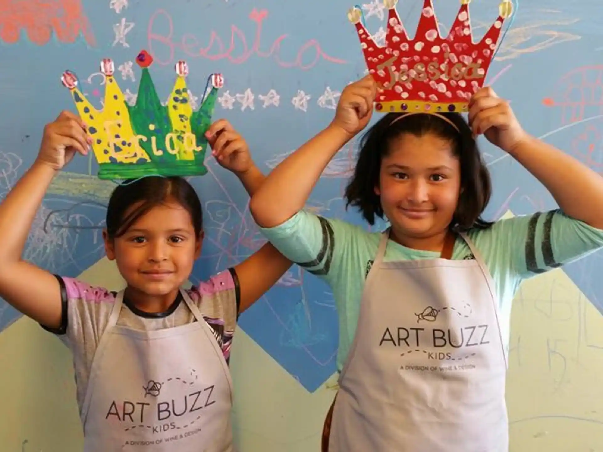 a couple of girls holding up a crown with a crown