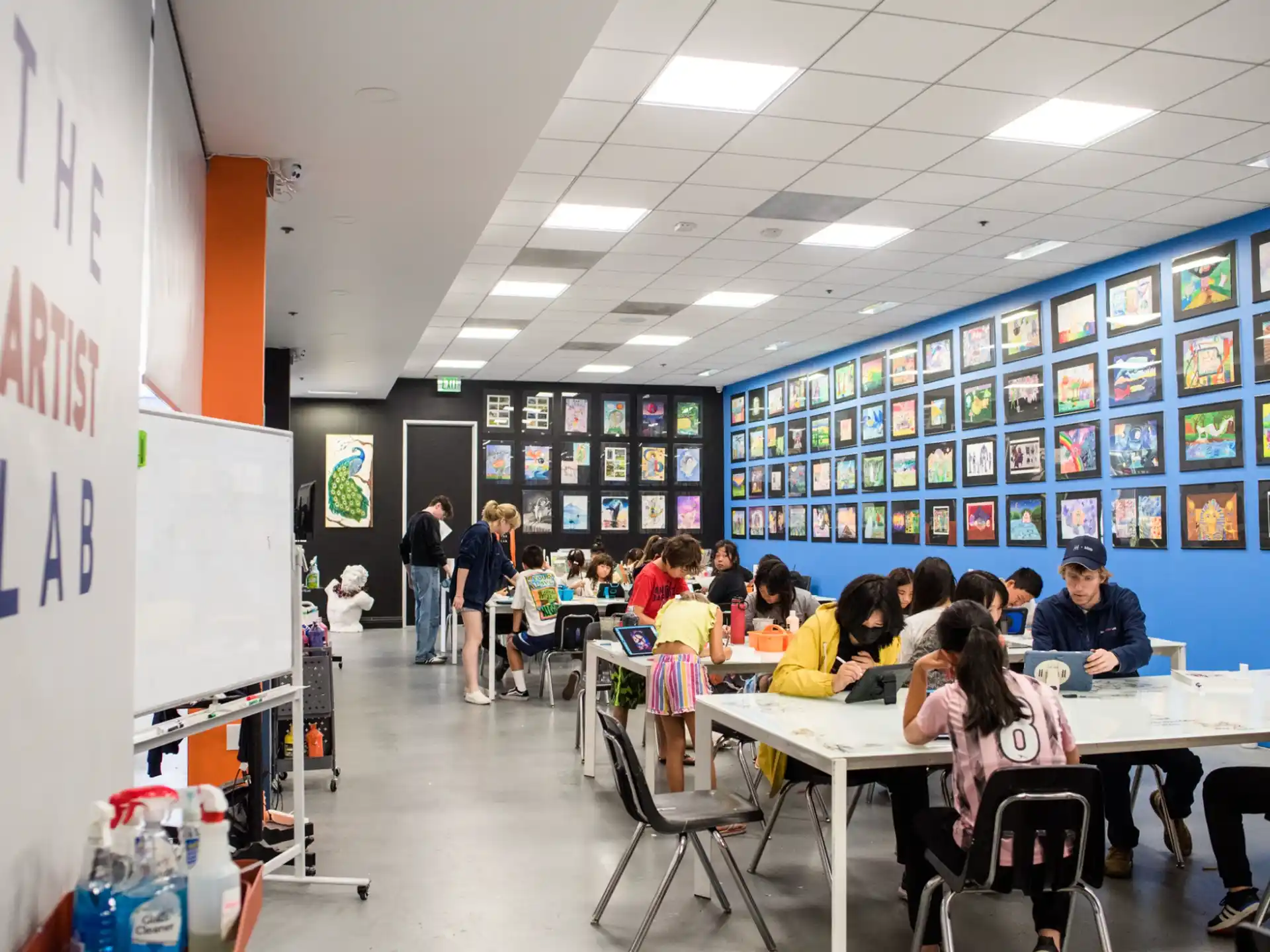 a group of people sitting at tables in a room with blue walls