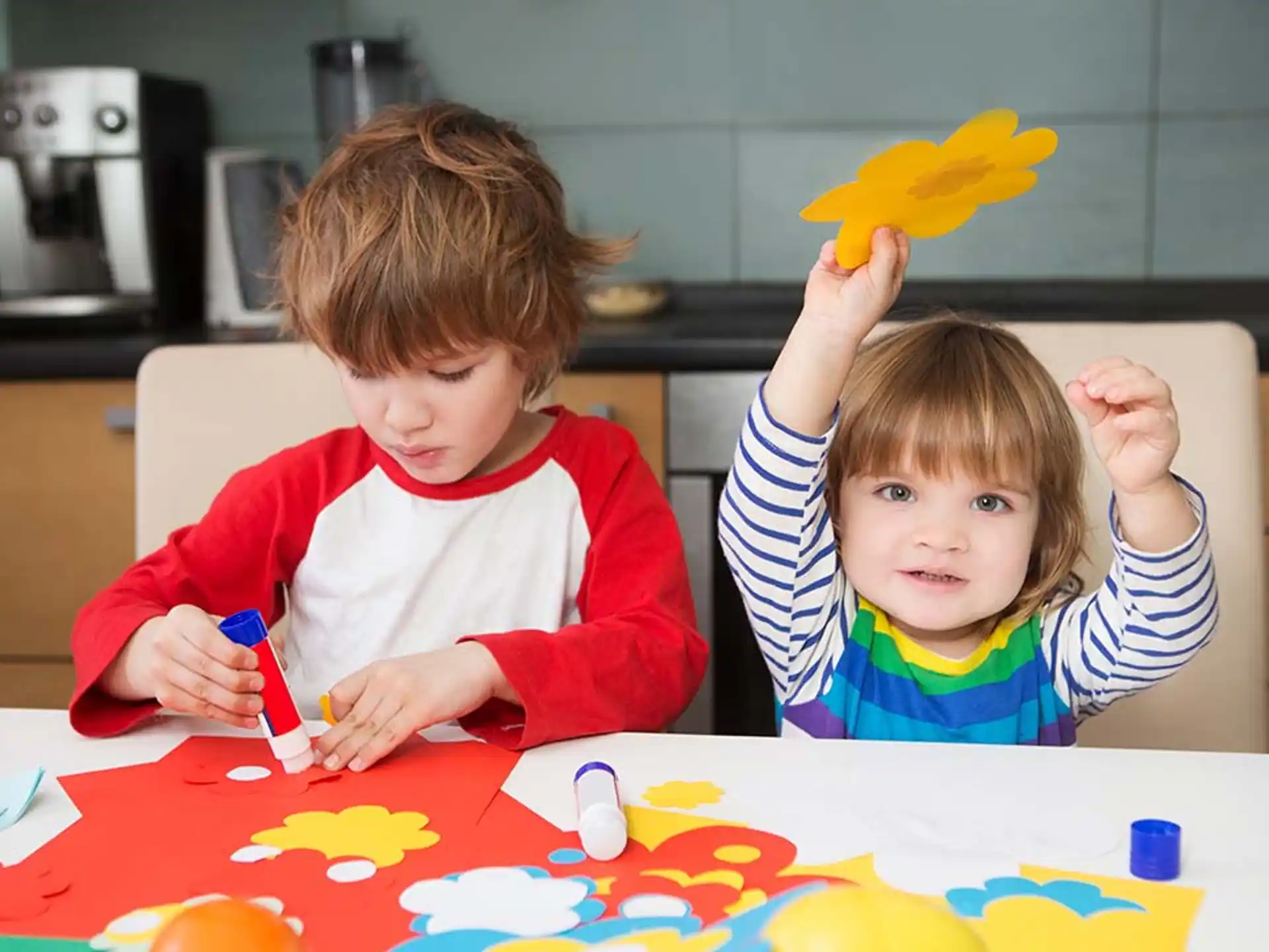 a couple of kids sitting at a table with a yellow star on it