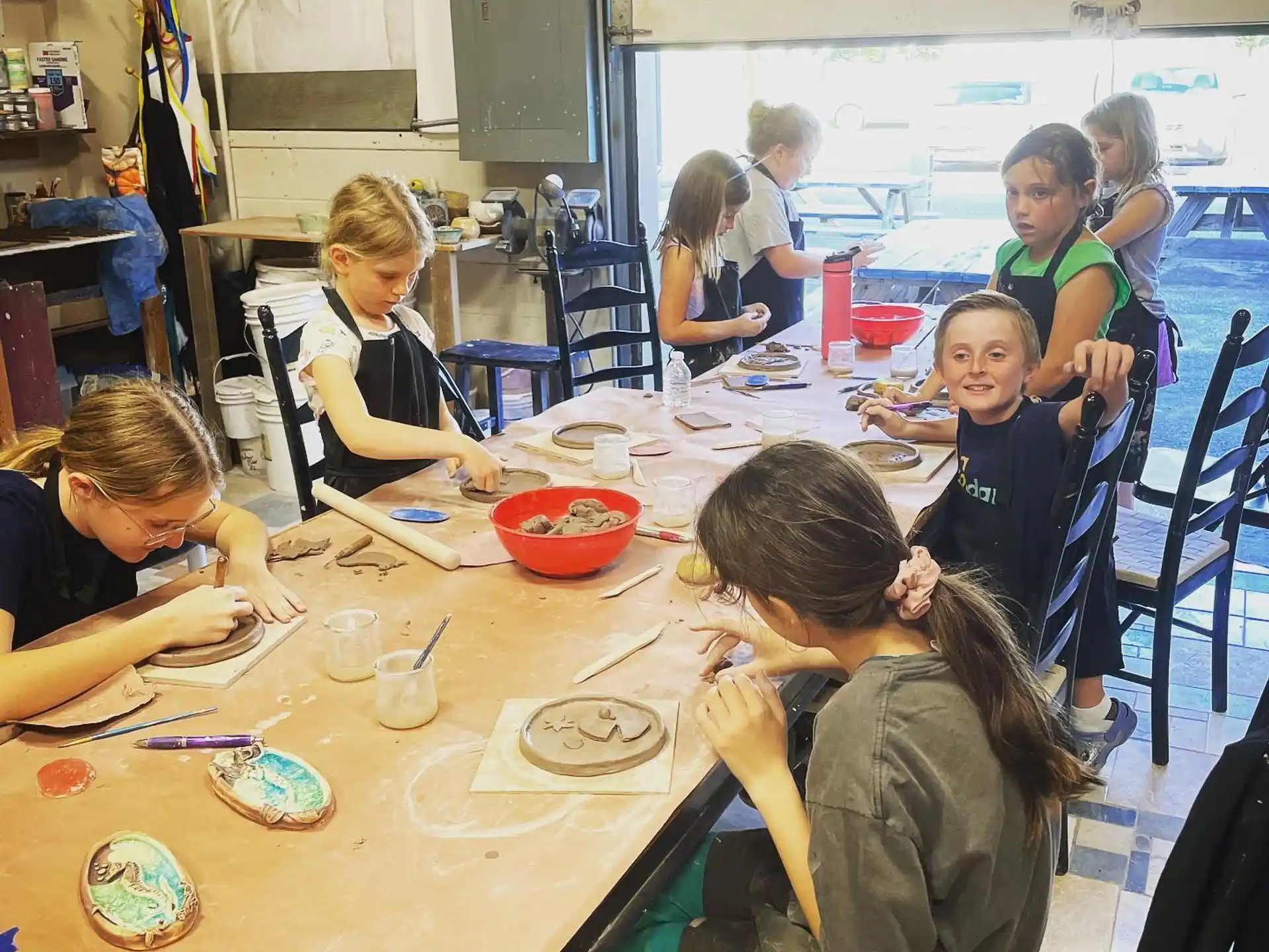 a group of children sitting at a table eating food