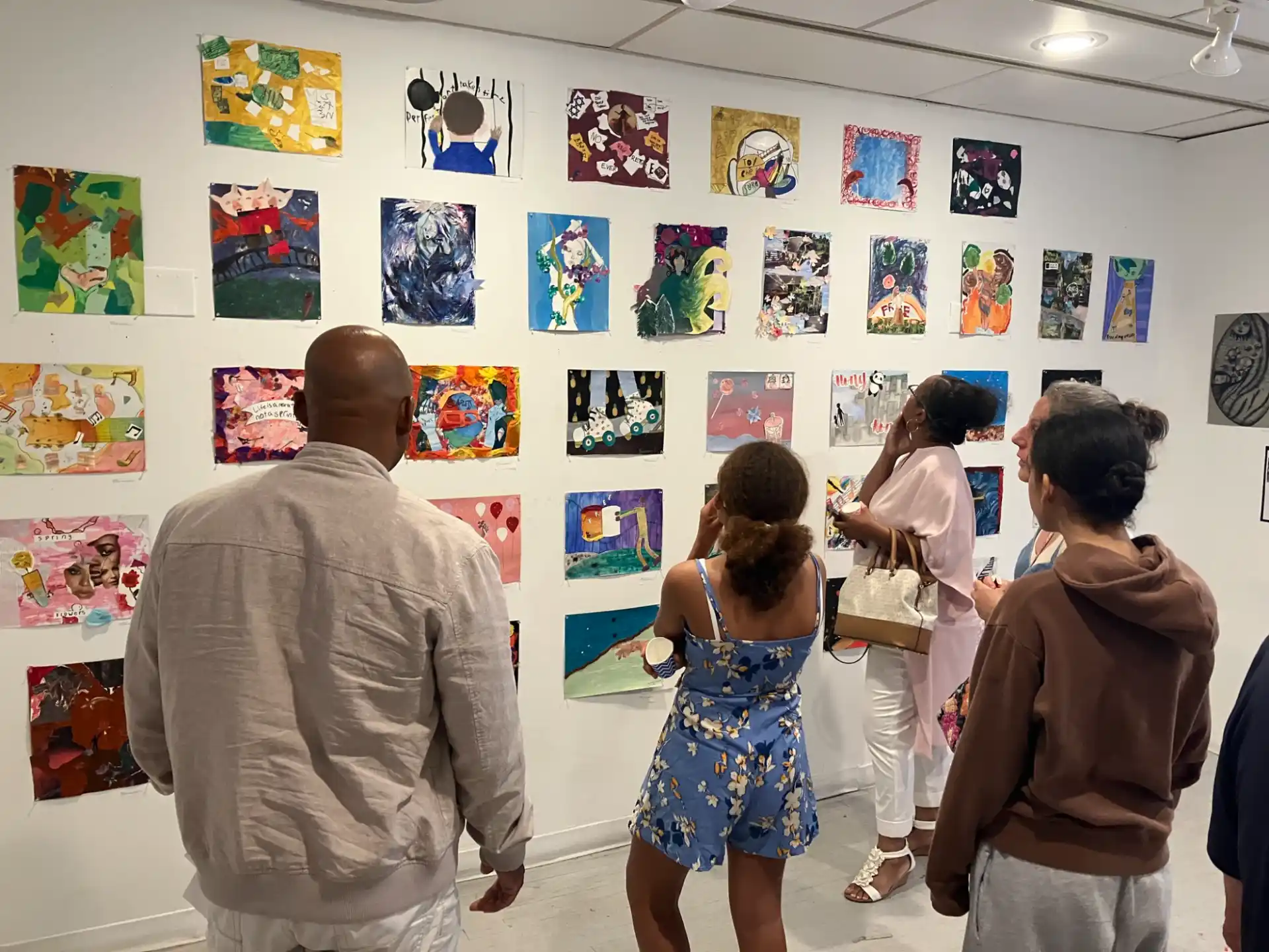 a group of people looking at a wall of posters
