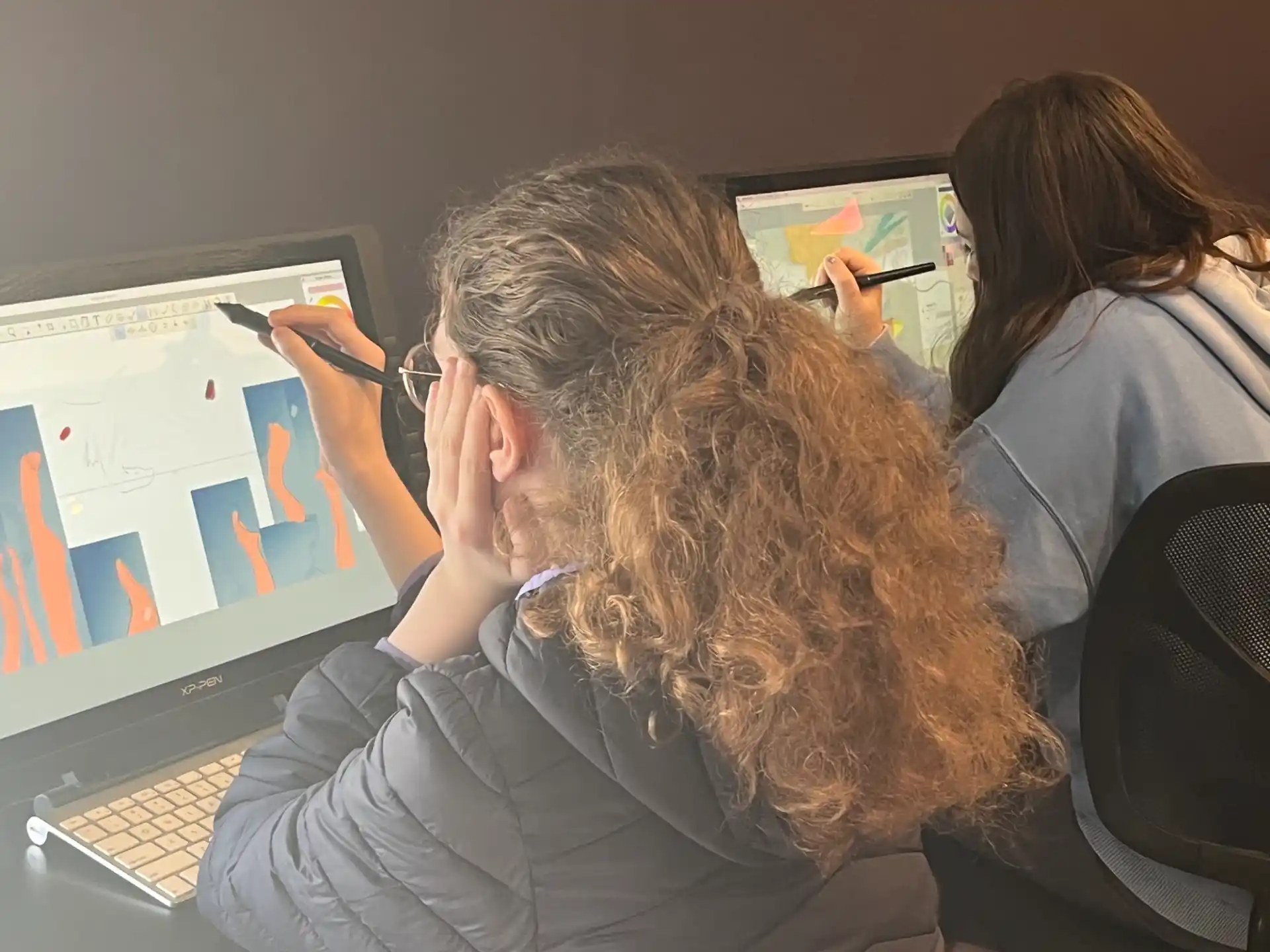 a woman with her hand on her face looking at a computer screen