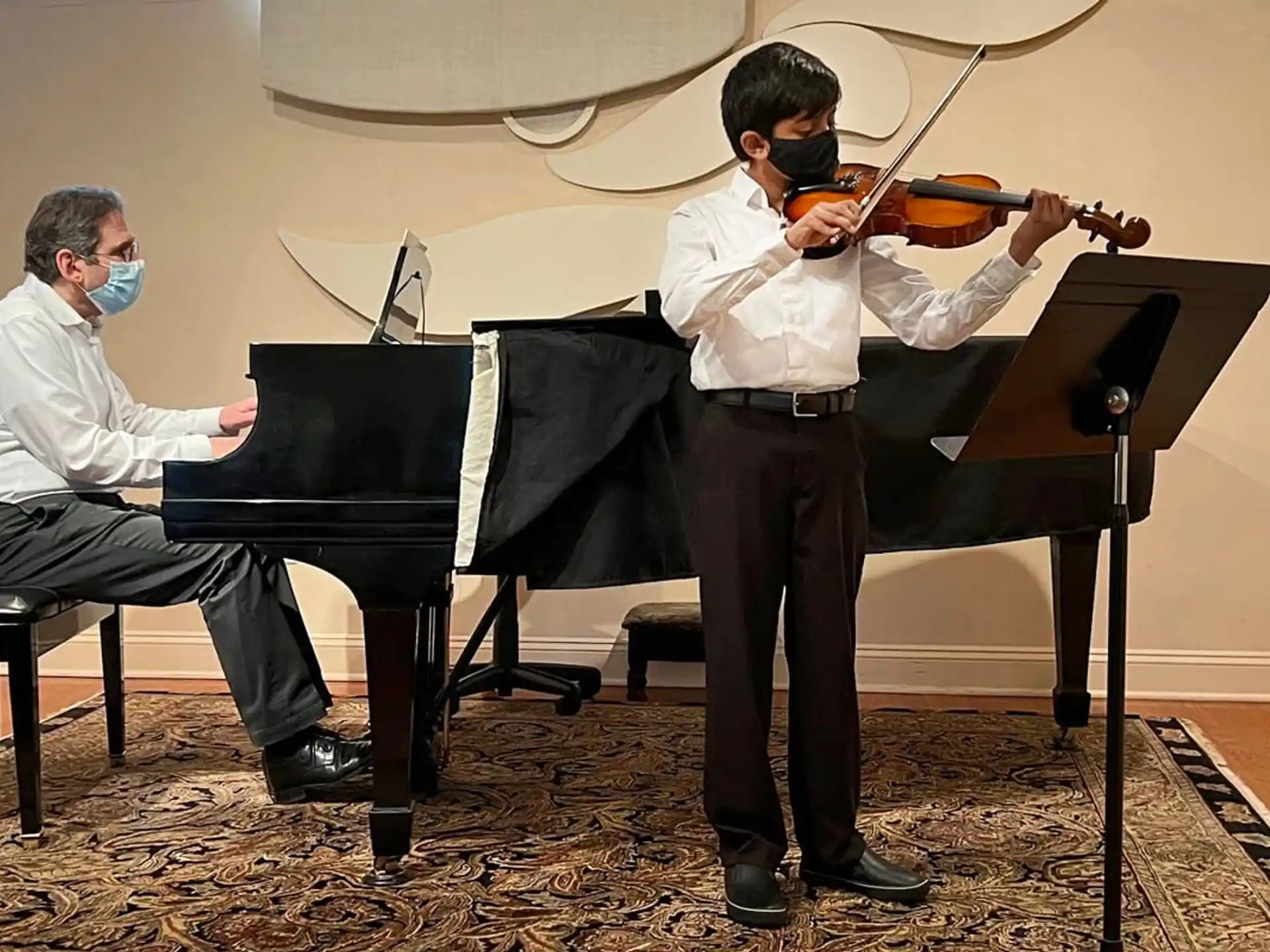 a man playing a violin next to a man playing a piano