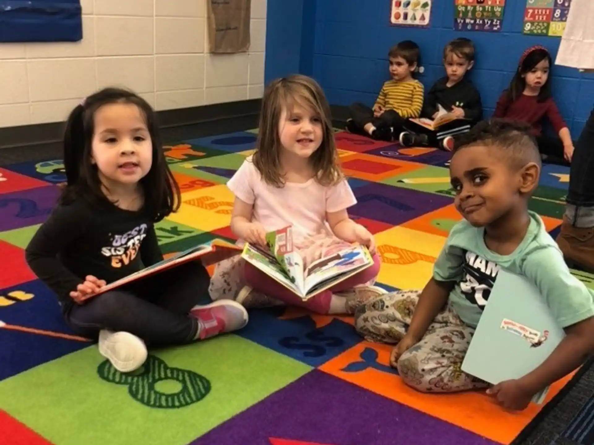 a group of children sitting on the floor reading books
