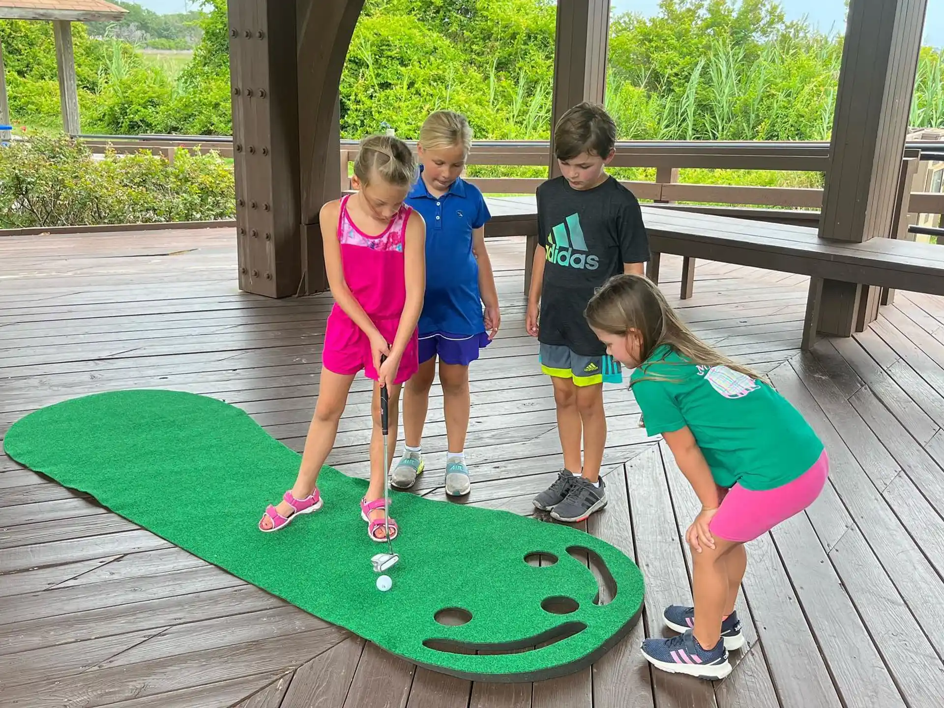 a group of kids standing on a green skateboard