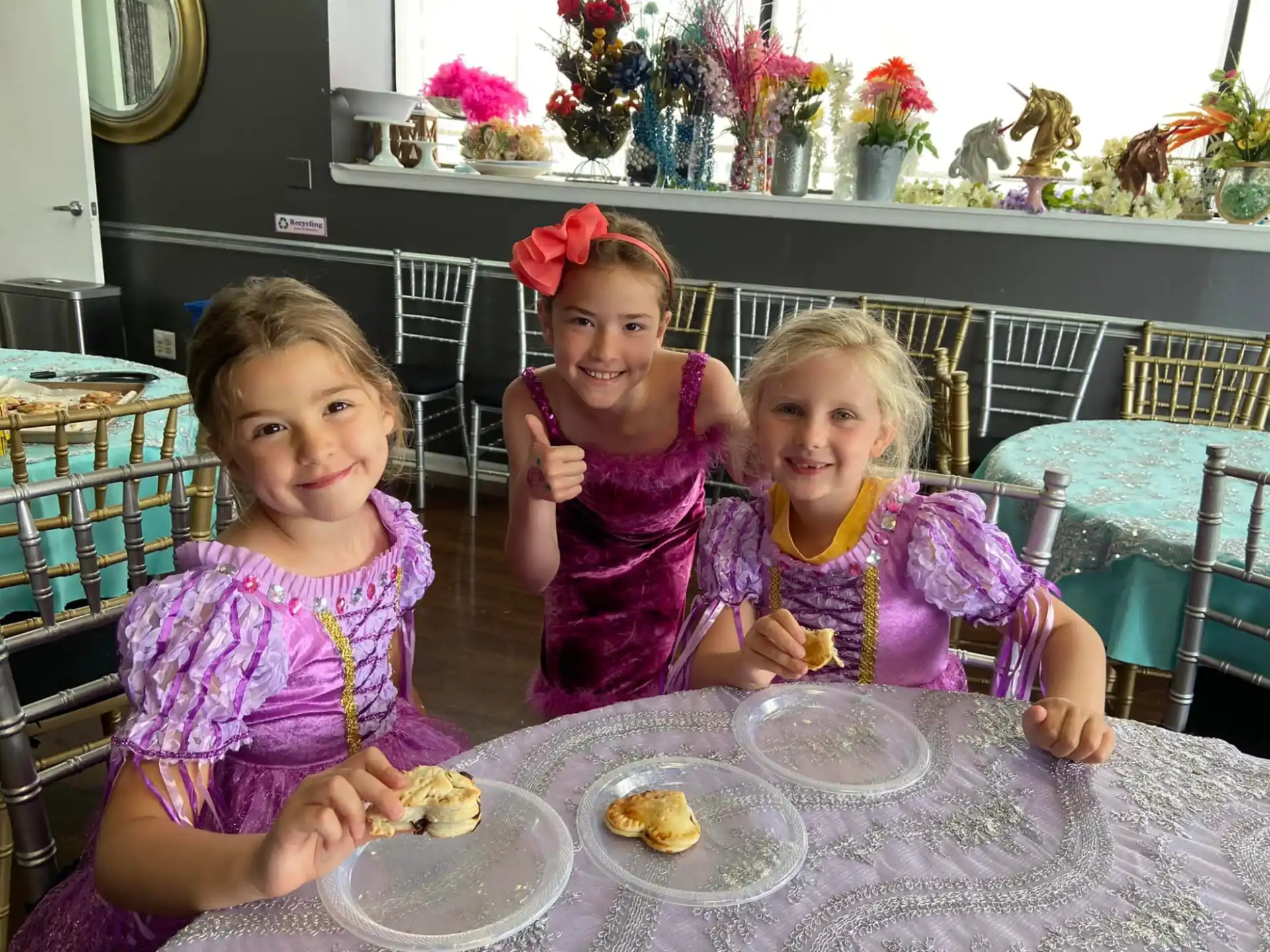 a group of girls sitting at a table with food