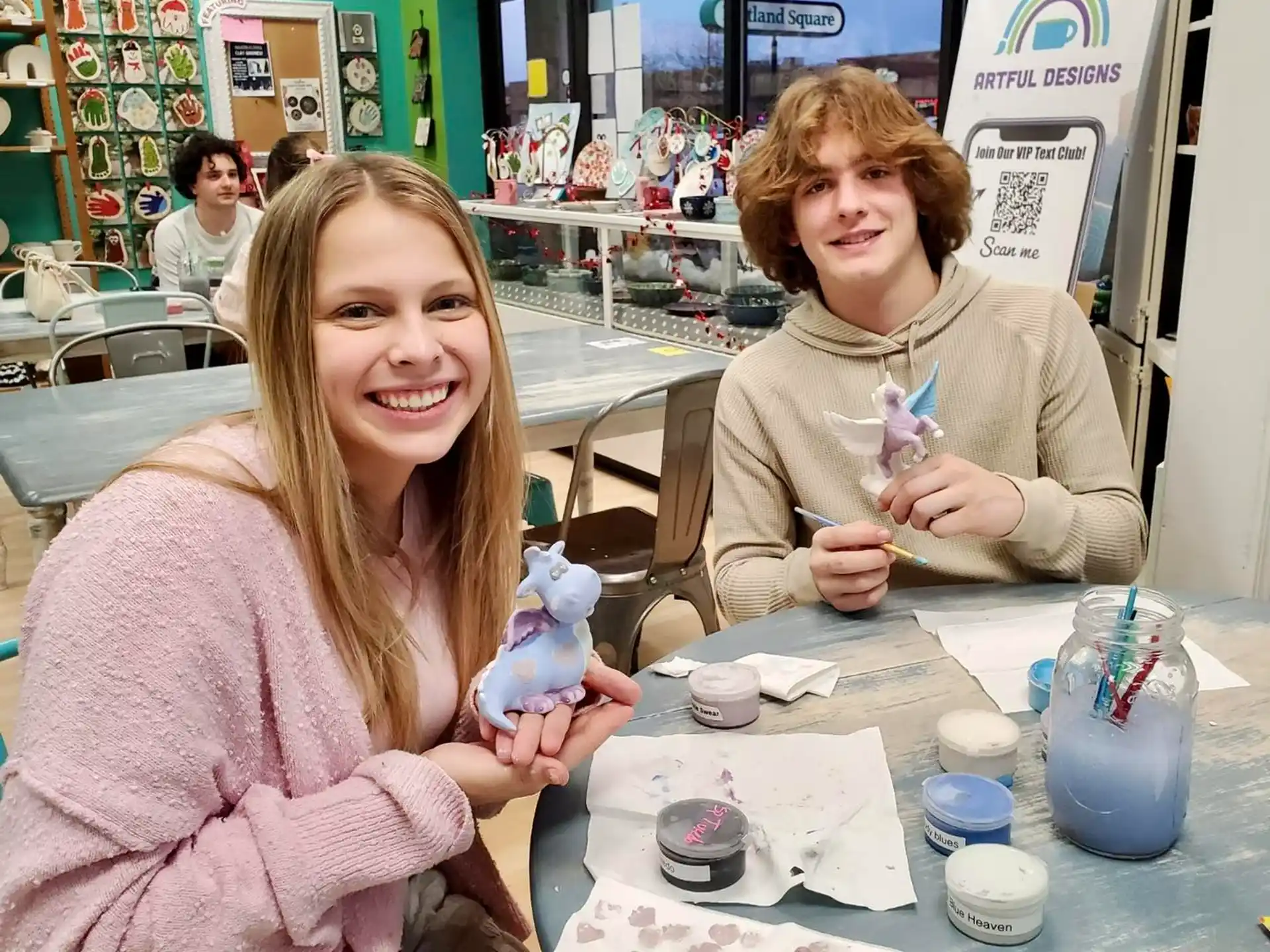 a couple of women sitting at a table with a child holding a toy