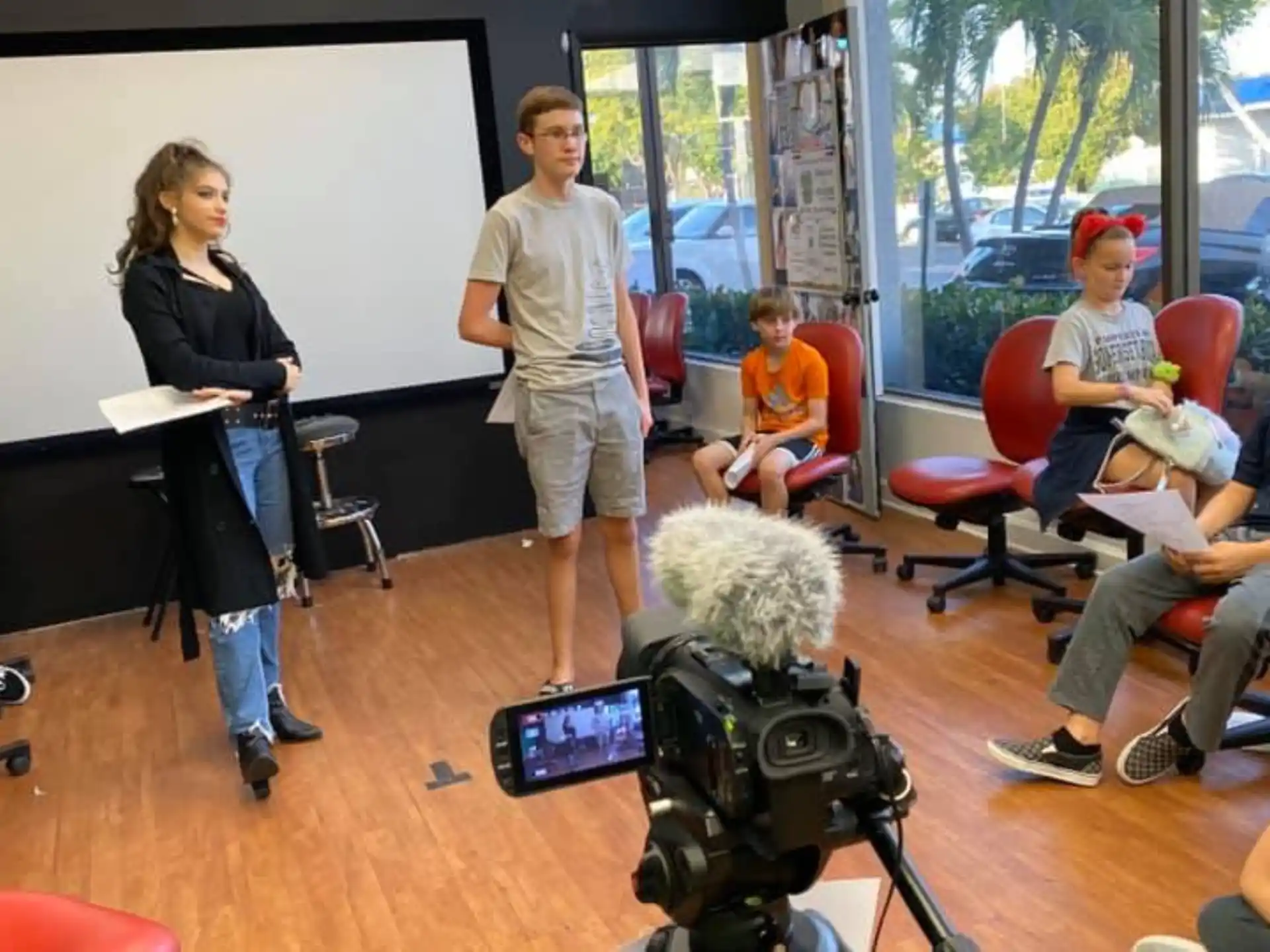 a person and a group of children in a room with a camera