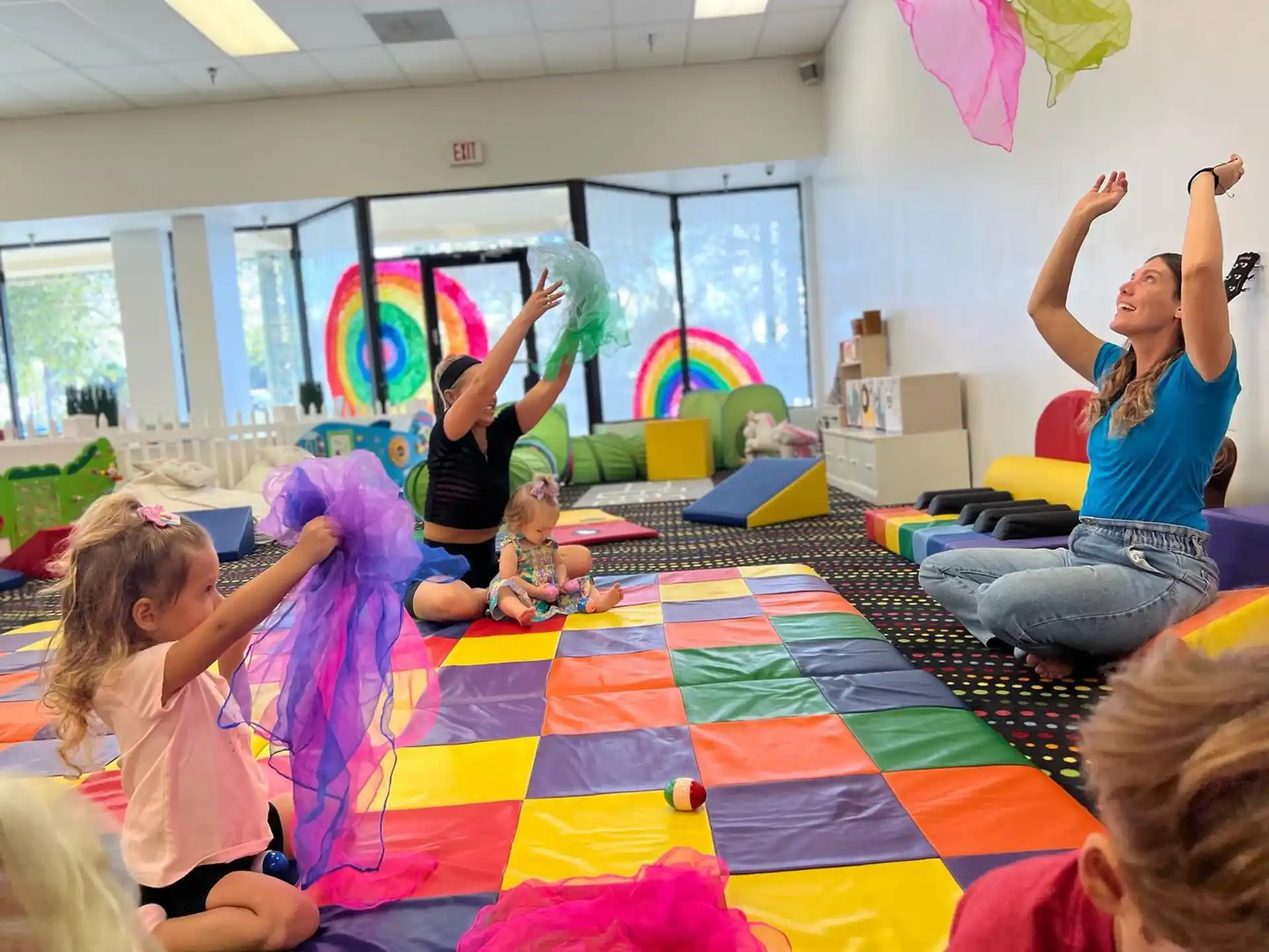 a group of children playing on a colorful rug in a room