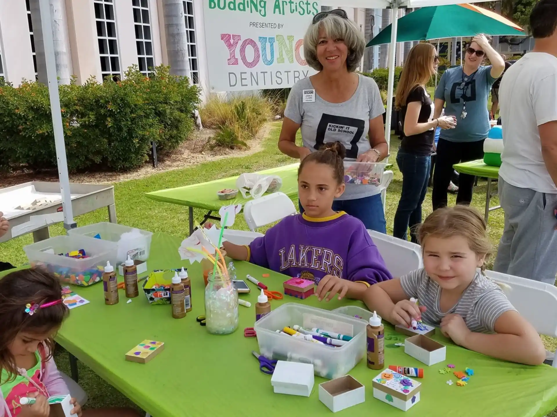 a group of children sitting at a table with food and drinks