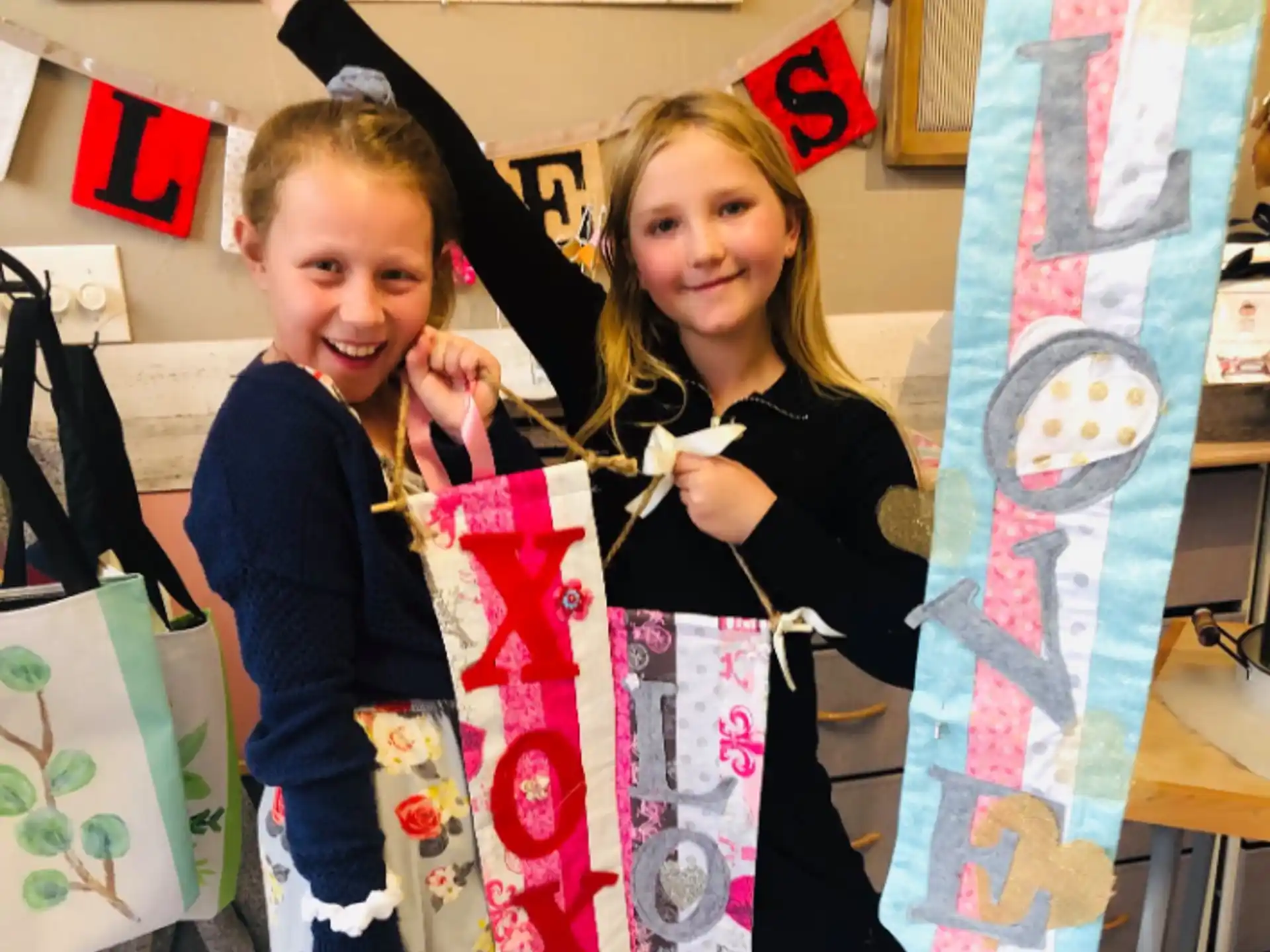 a couple of girls holding up a kite