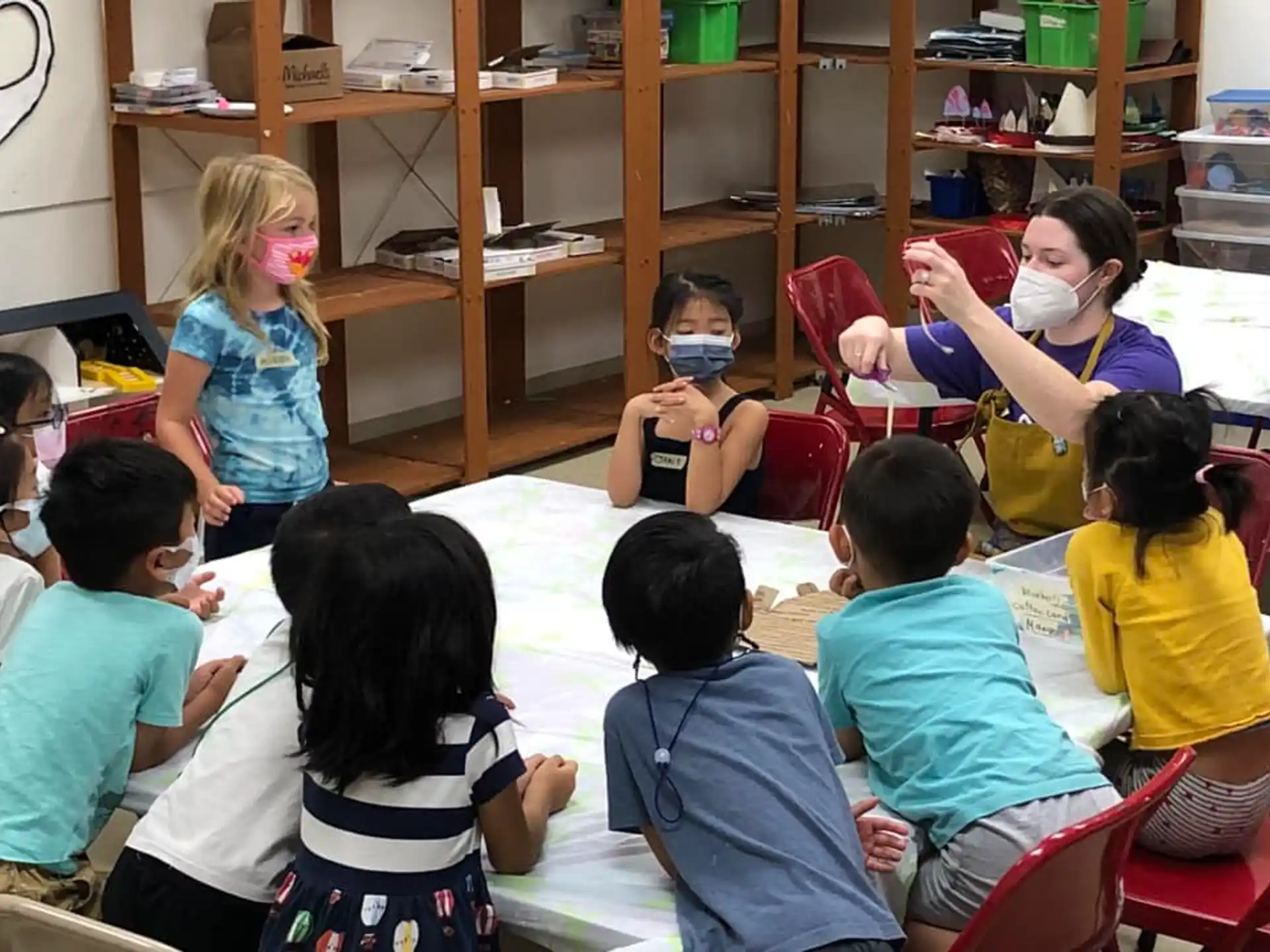 a group of children sitting in a circle in a classroom