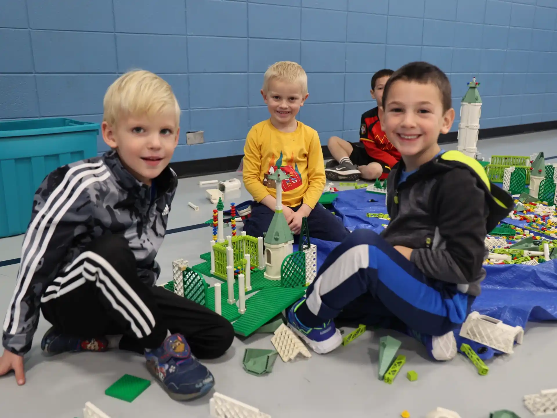 a group of boys sitting on the floor with a toy train