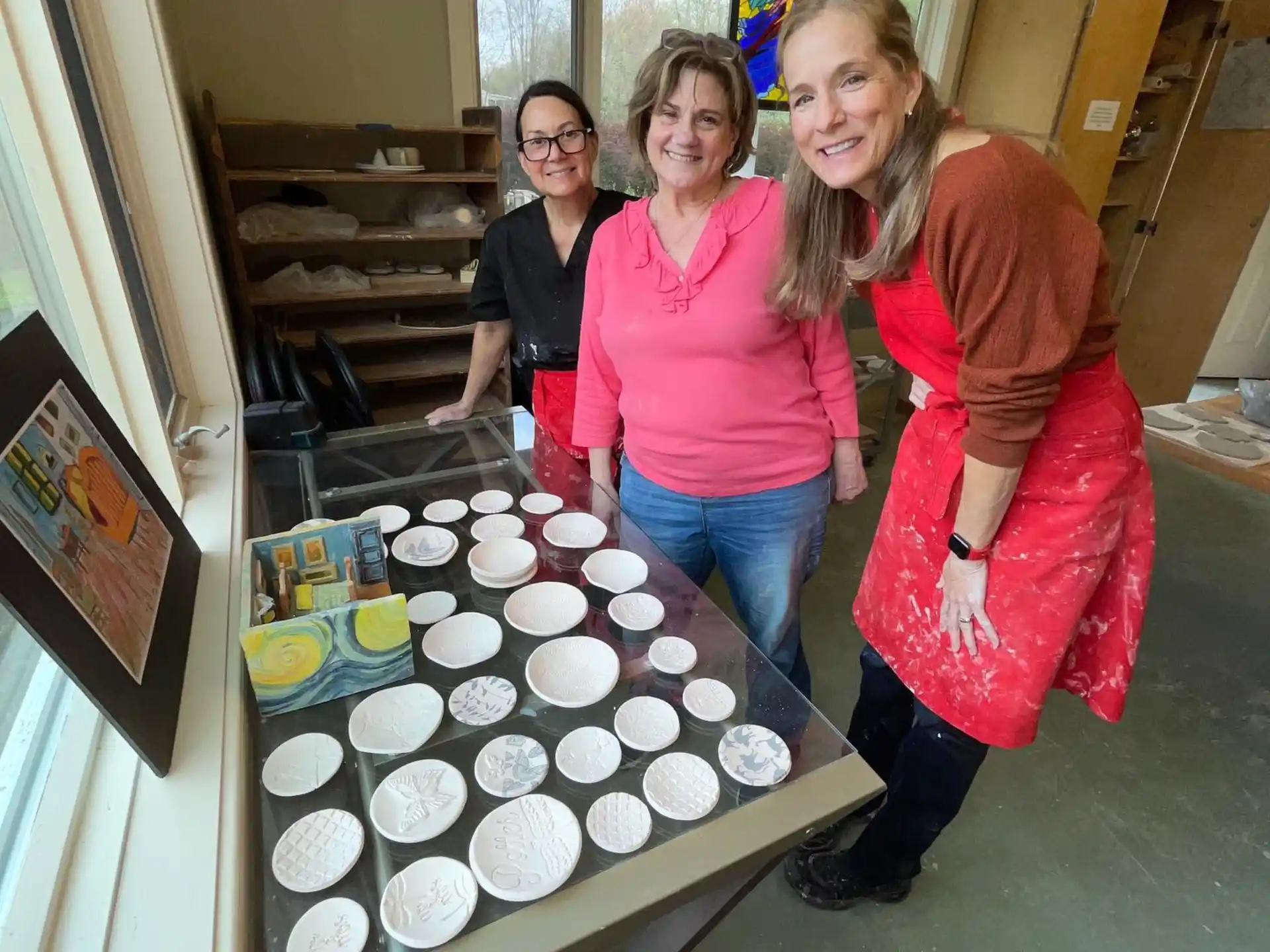 a group of women standing next to a counter with food on it