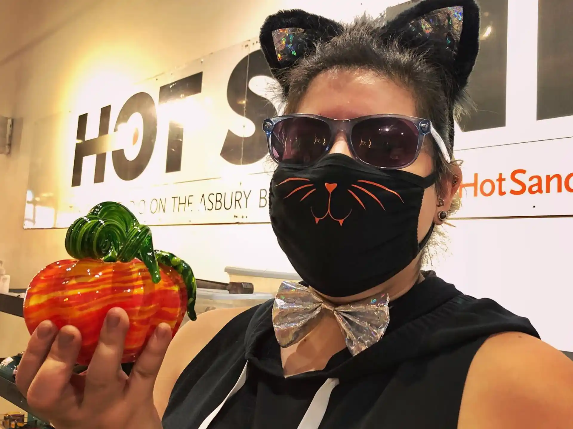 a person wearing a mask and holding a strawberry