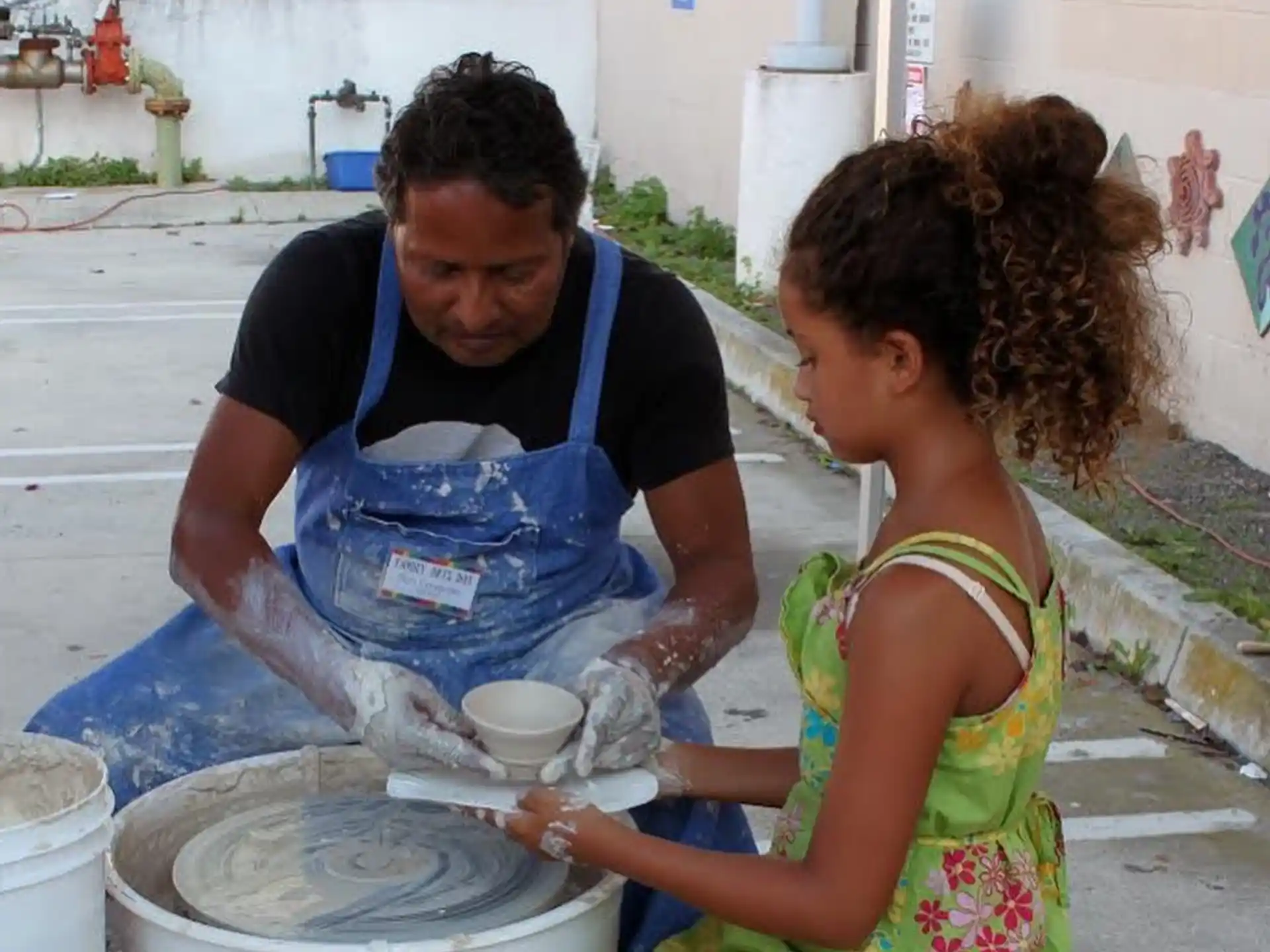 a man and a woman pouring water into a bucket
