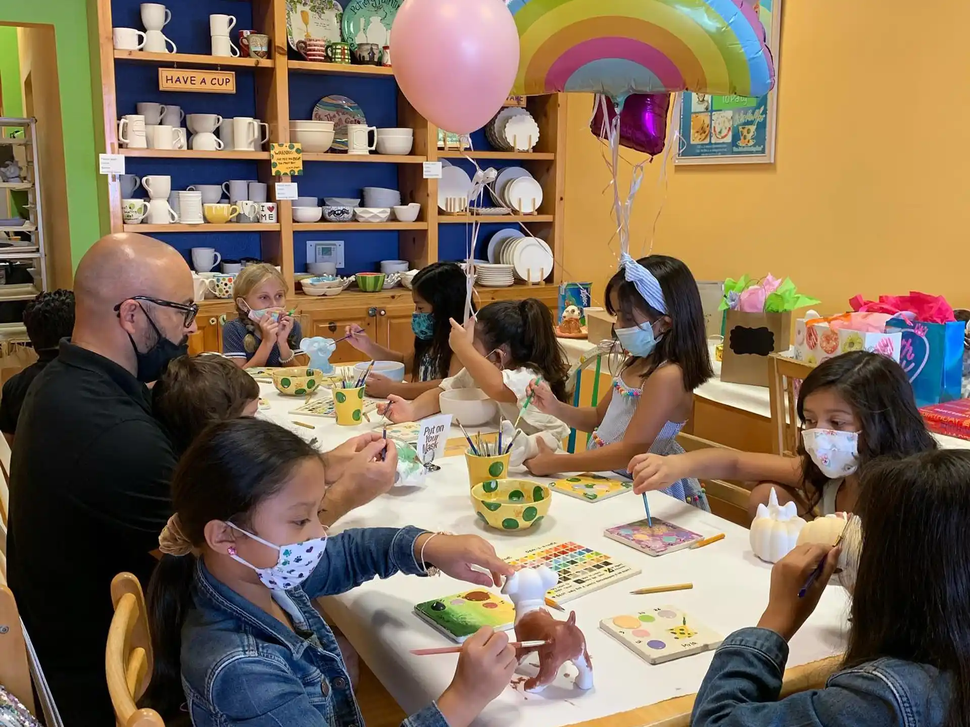 a group of people sitting around a table with balloons