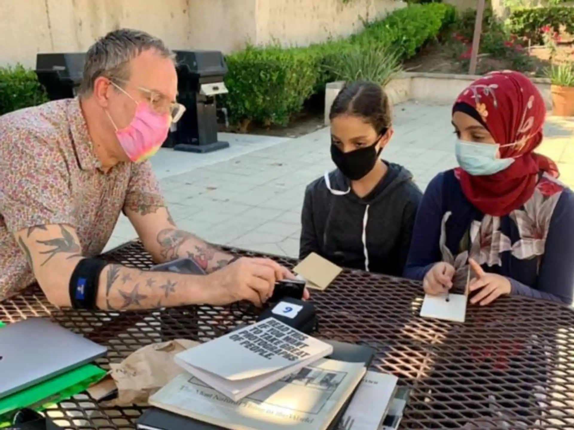 a man and a couple of kids sitting at a table with a board game