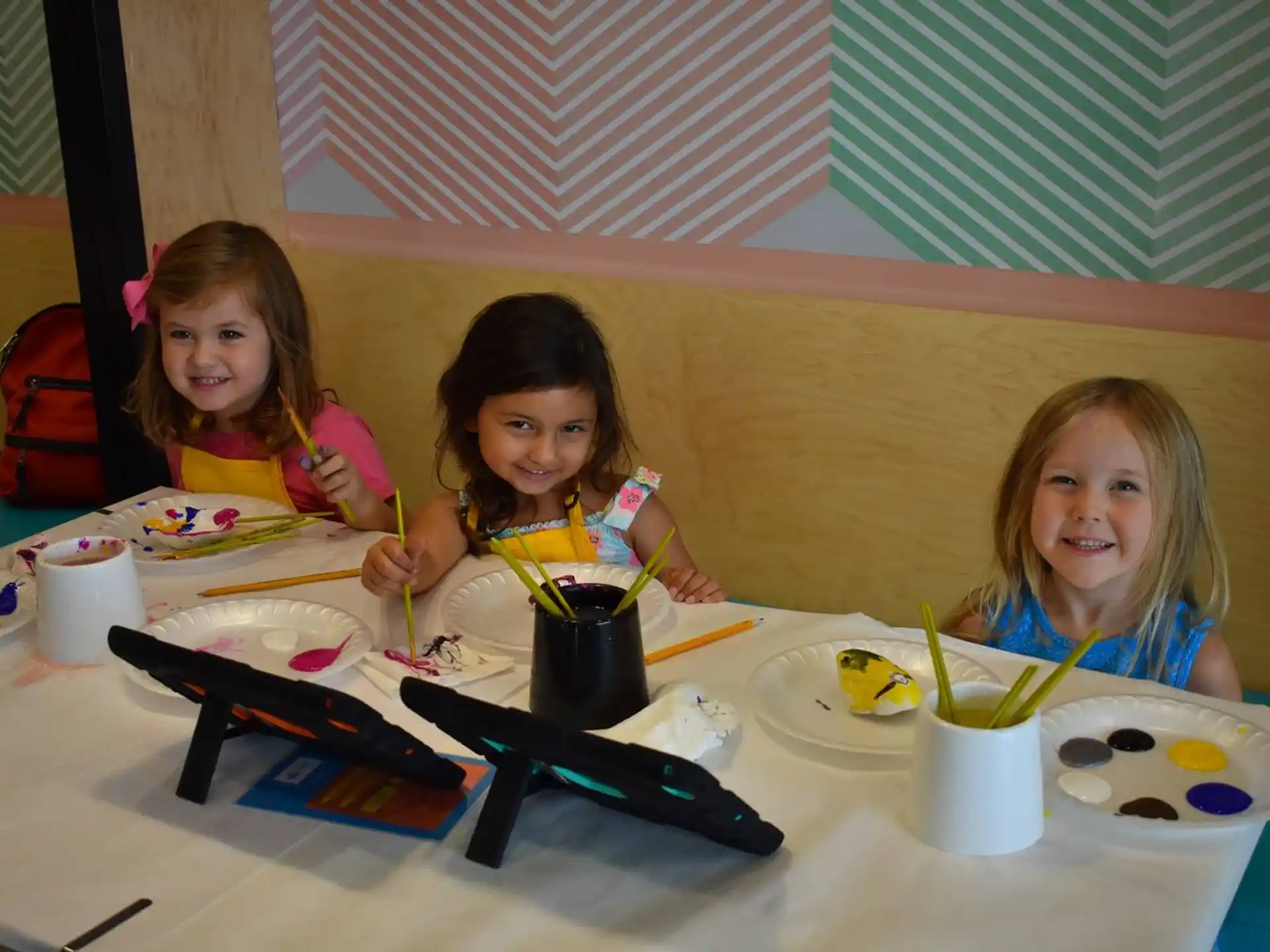 a group of girls sitting at a table with food