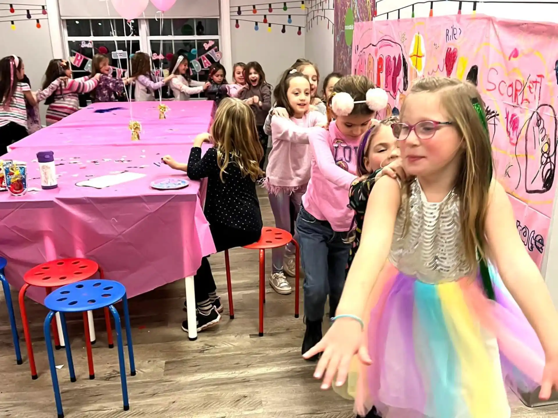 a girl dancing in a room with people in the back