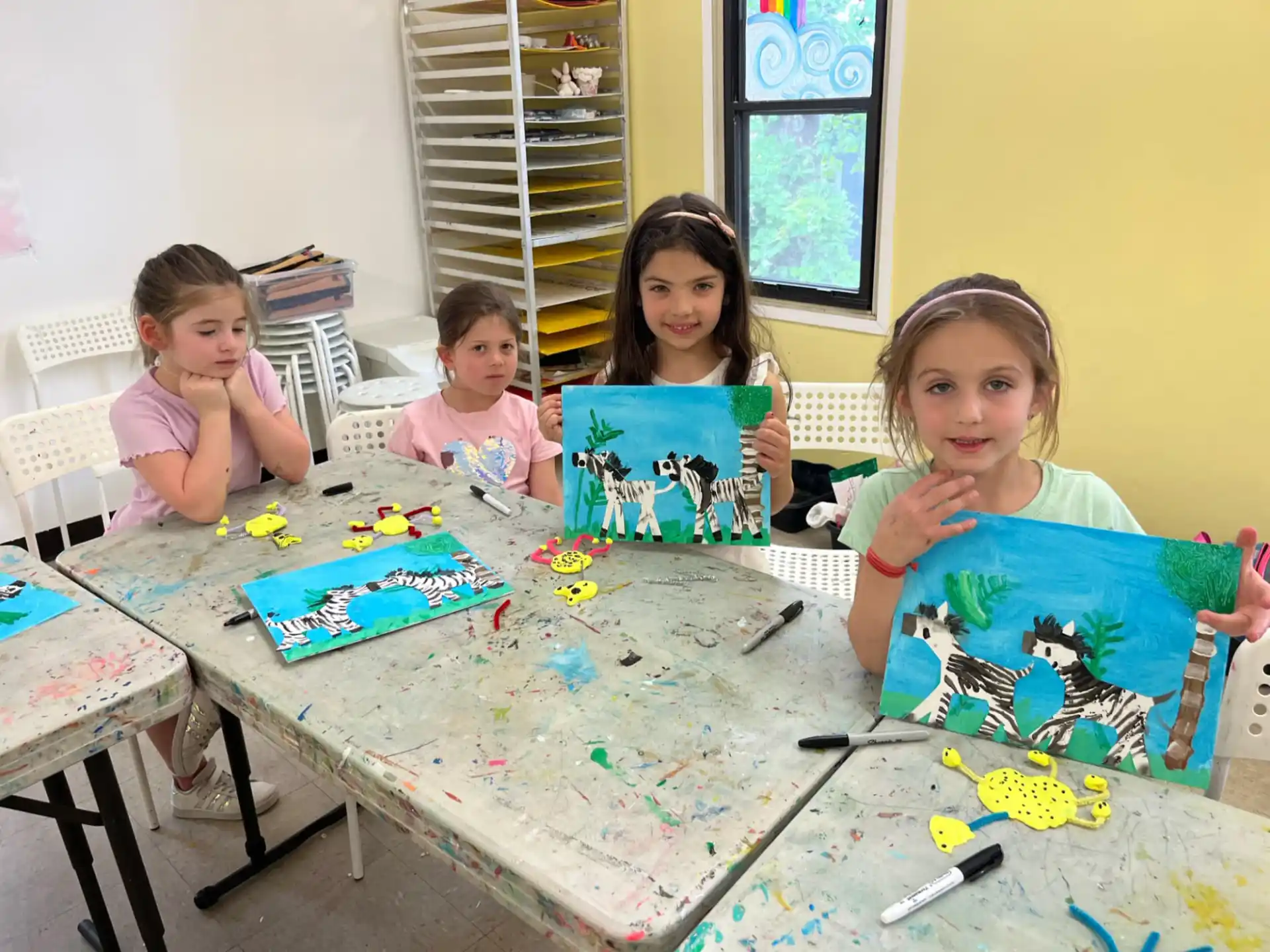 a group of children sitting at a table with toys