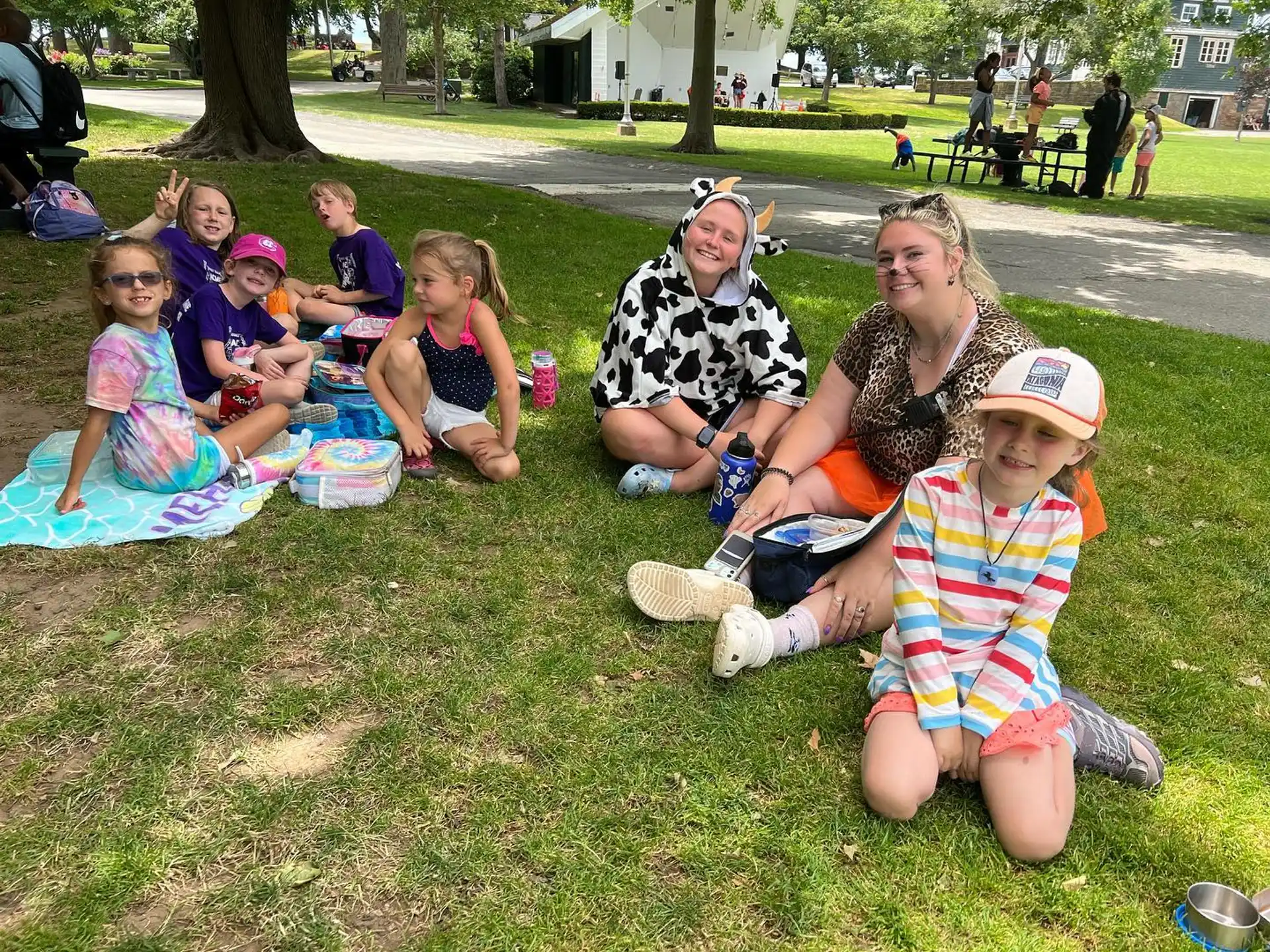 a group of people sitting on the grass