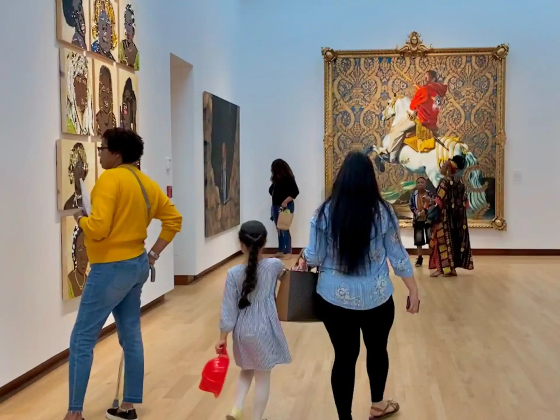 a group of people looking at art on the wall