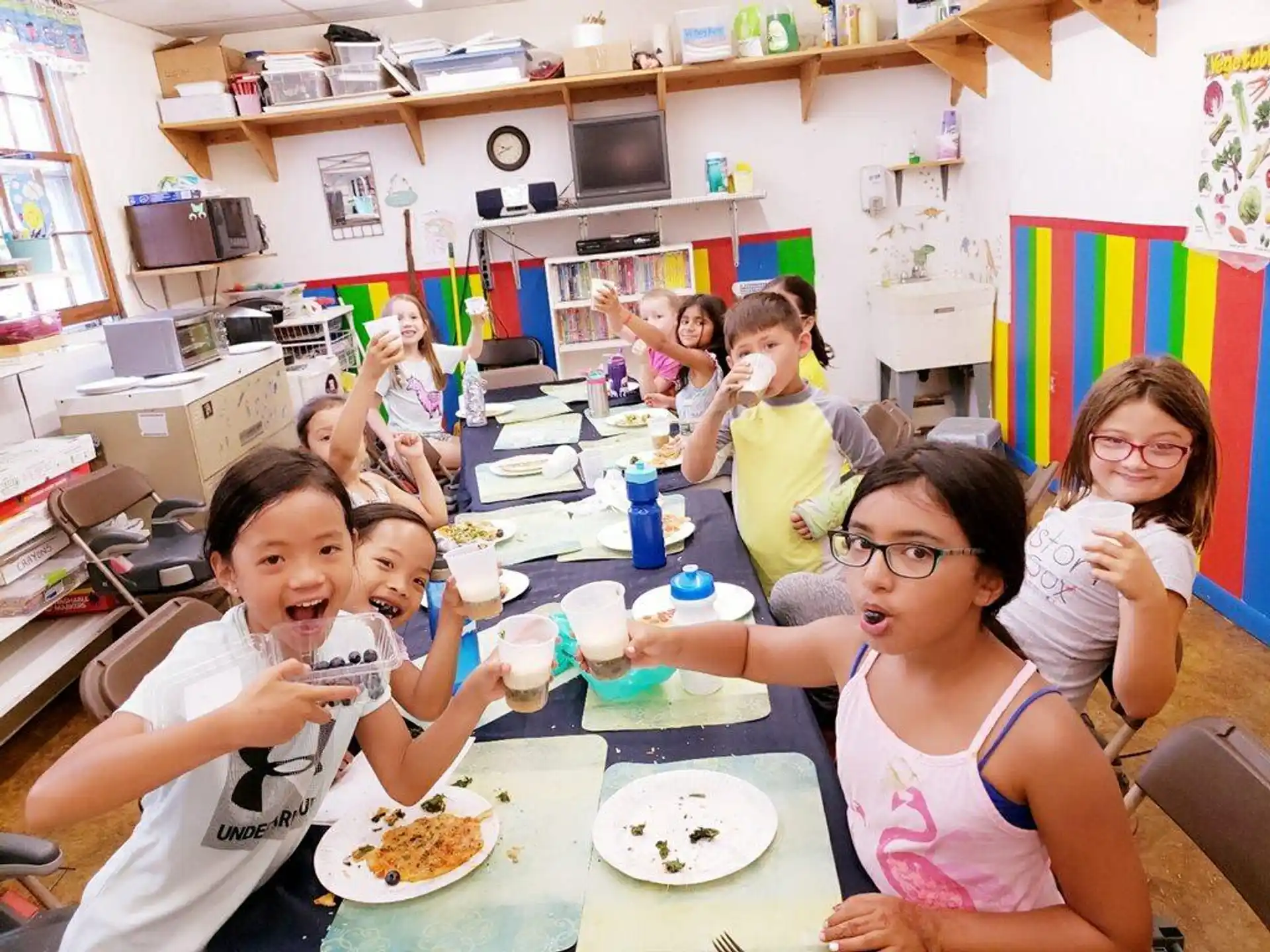 a group of kids eating at a table