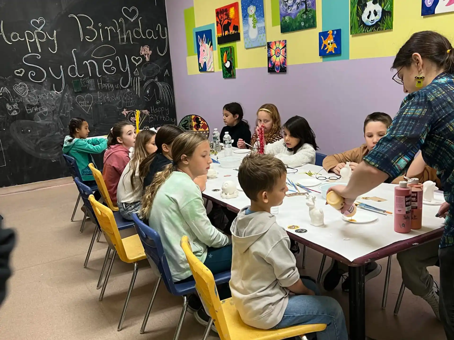a group of children sitting at a table in a classroom