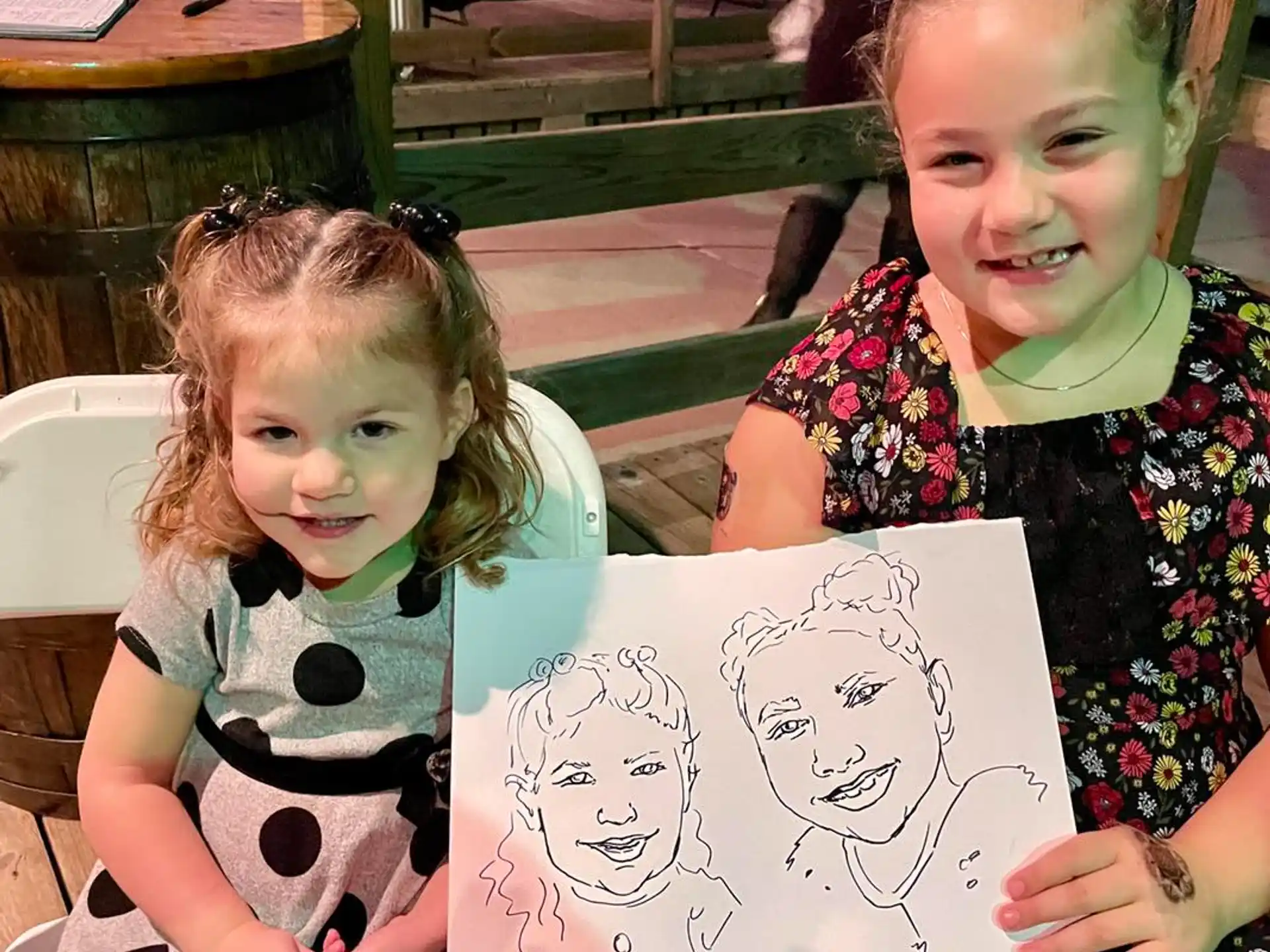 a couple of girls holding a drawing