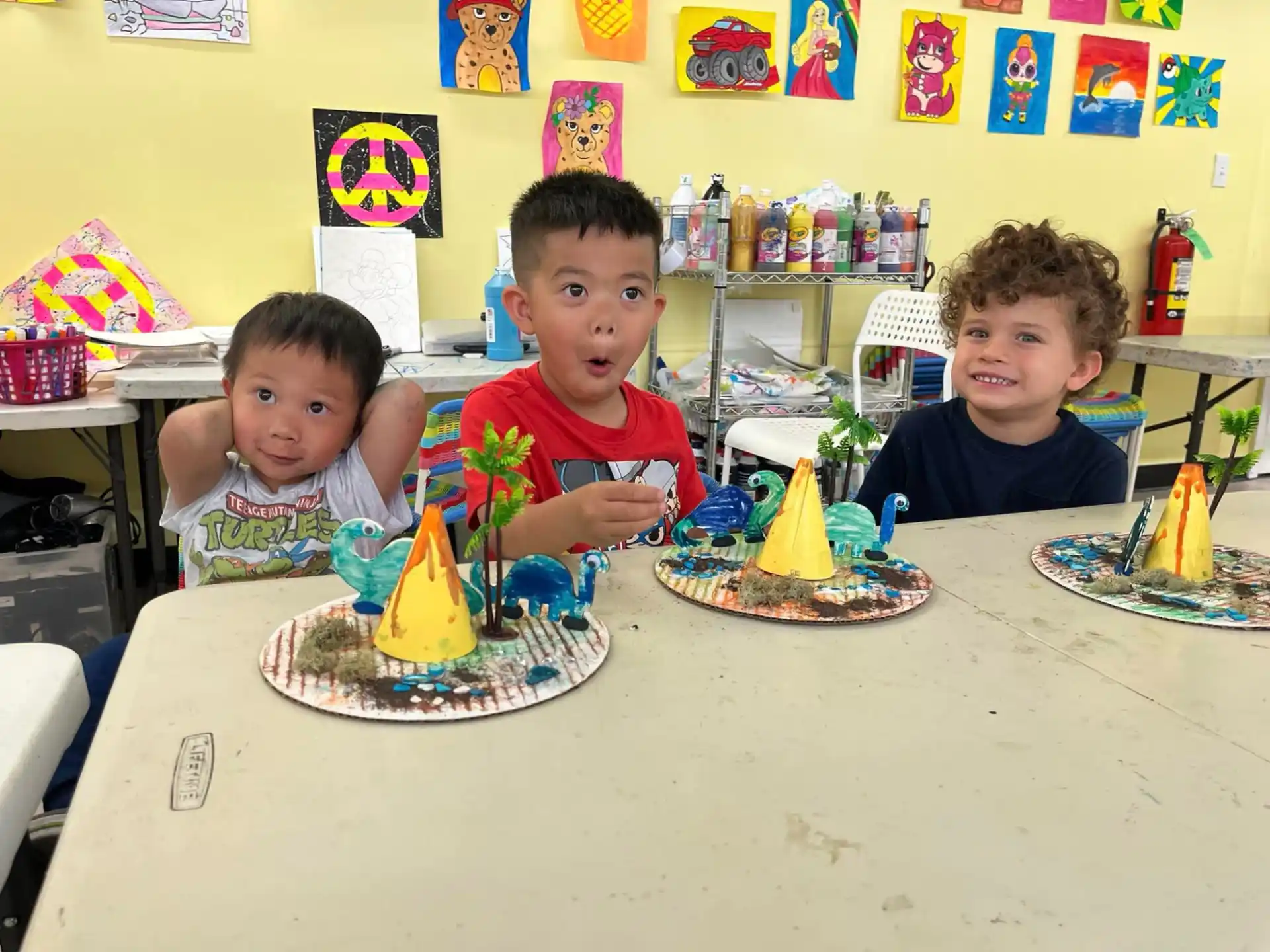 a group of kids sitting at a table with a birthday cake