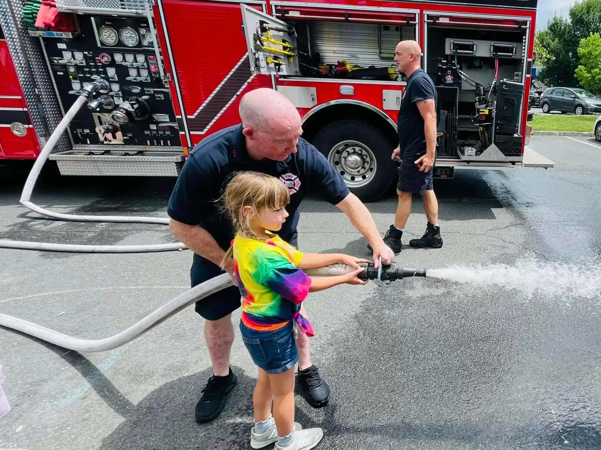 a person and a child standing by a fire truck