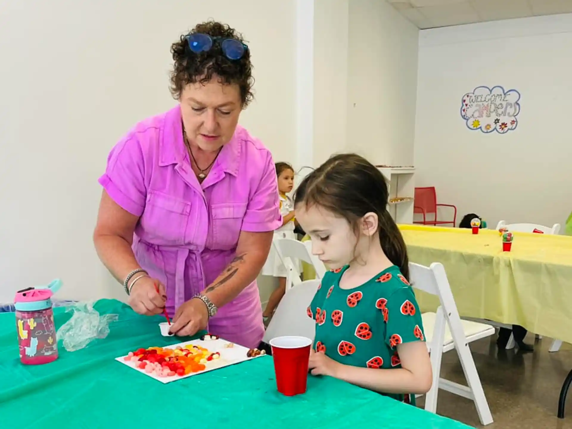 a person and a girl sitting at a table with food