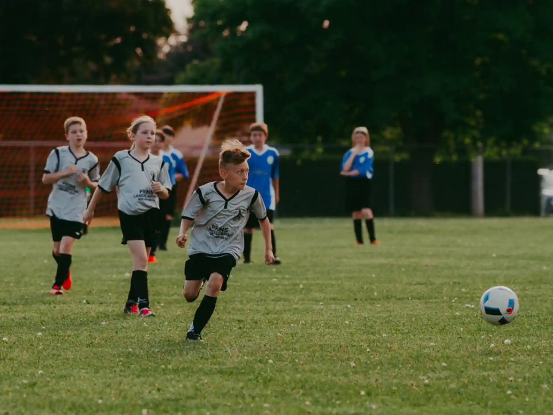 a group of kids compete over a football ball