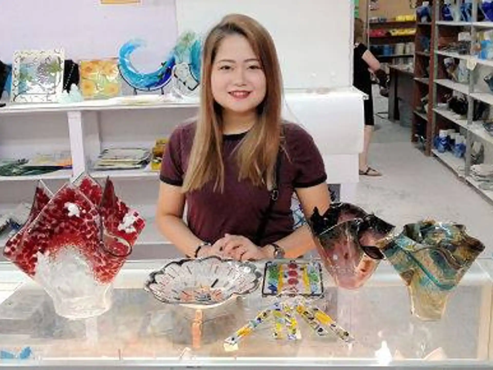 a woman sitting at a table with a large pile of toys
