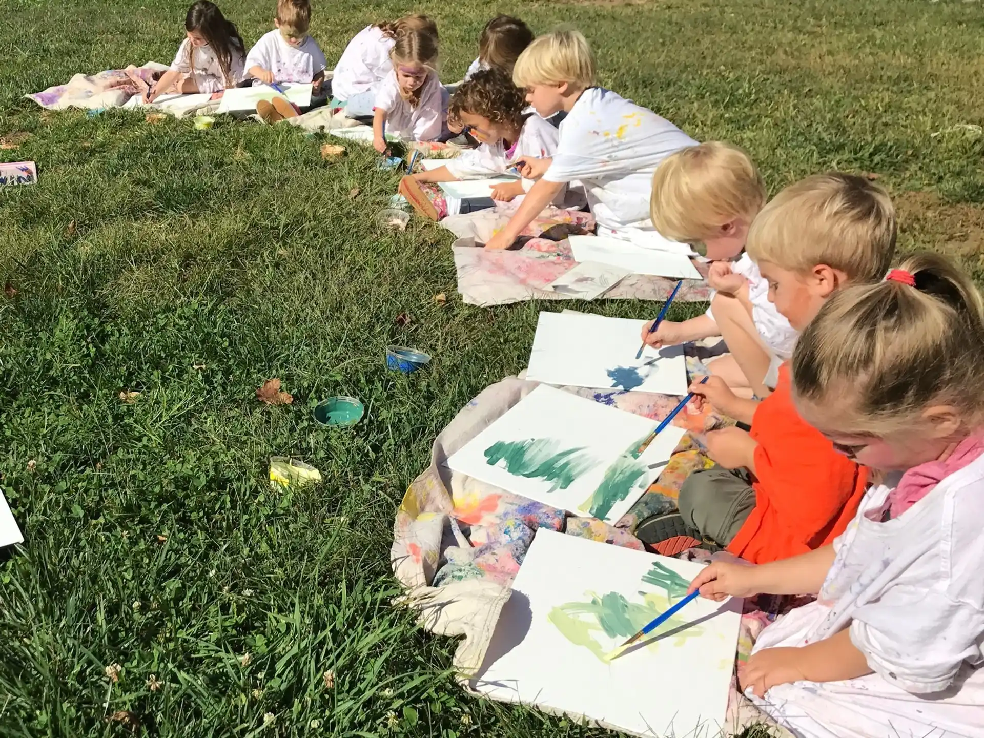 a group of children sitting on the grass