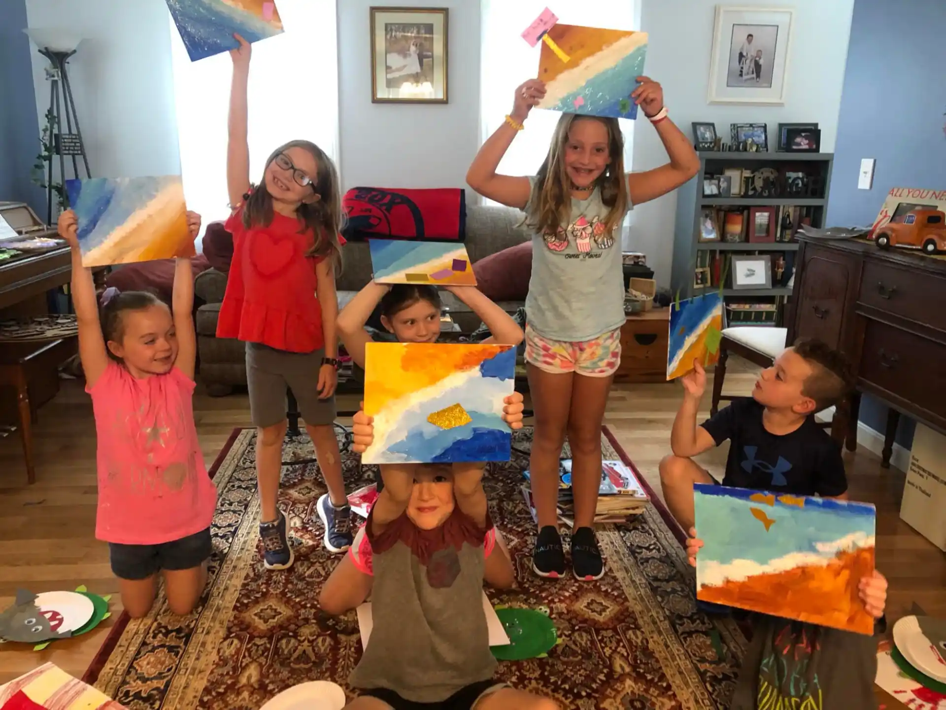 a group of children holding up a birthday cake