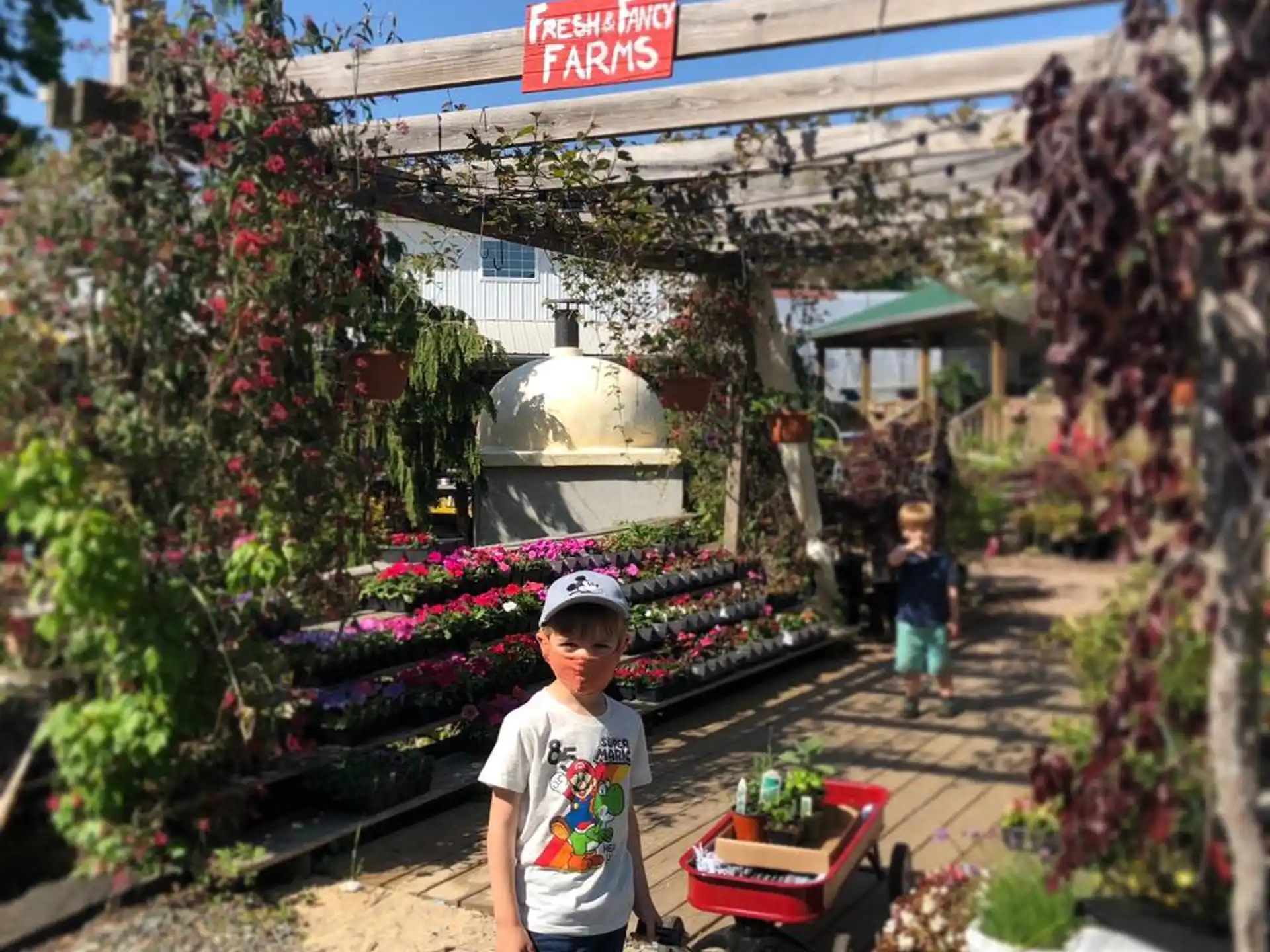 a boy standing in front of a flower shop