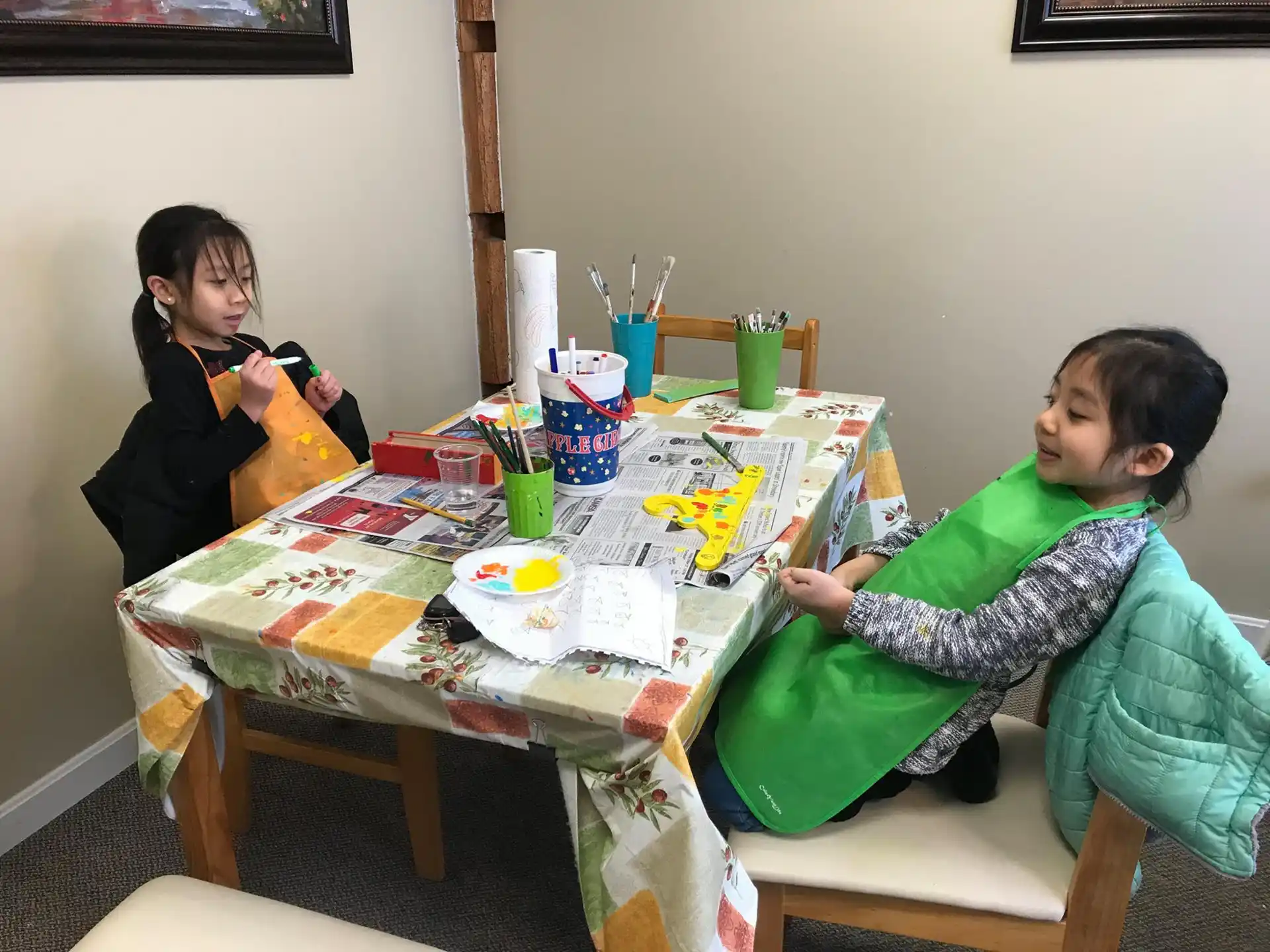 a person and a child sitting at a table with food and drinks
