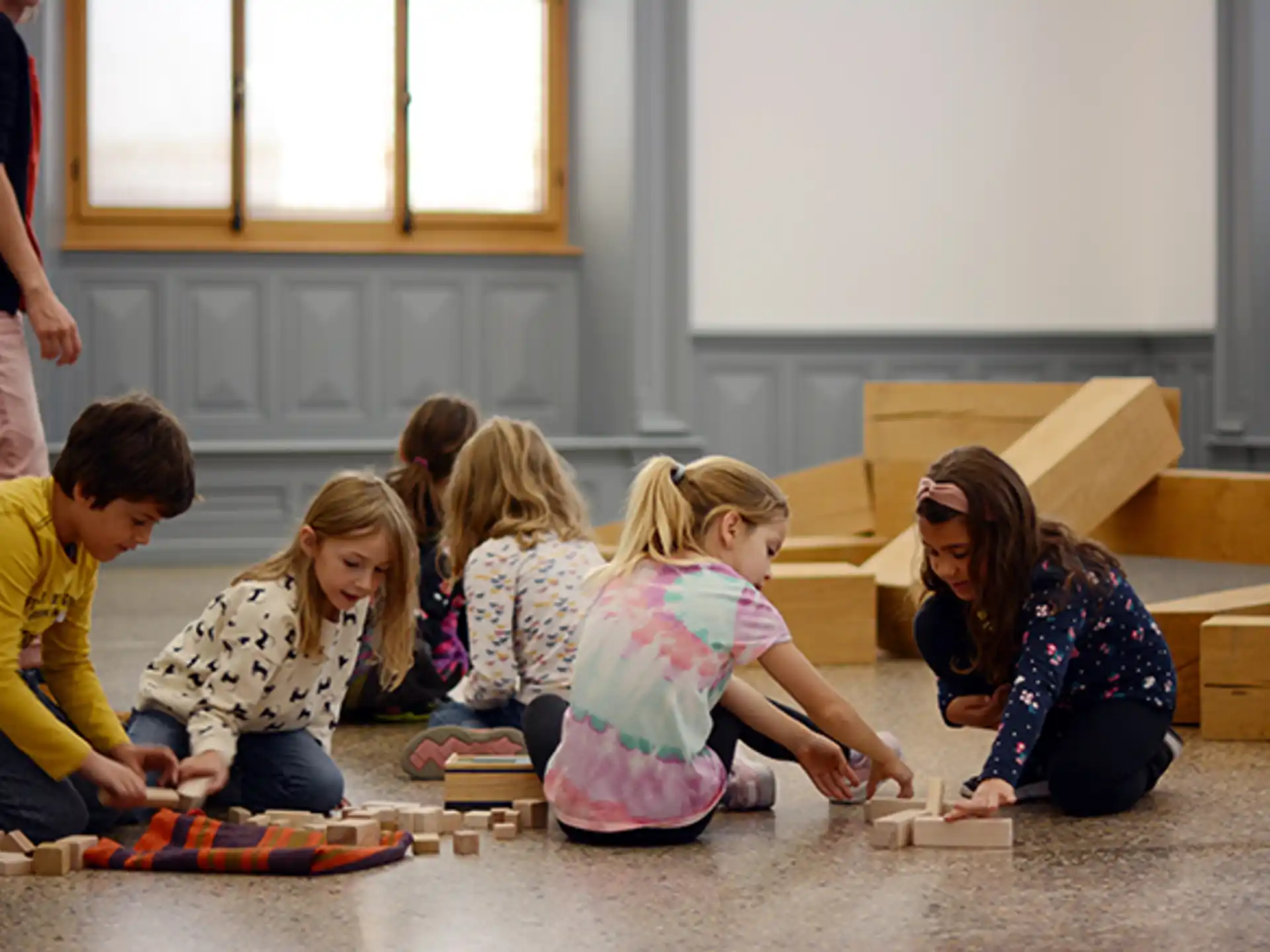 a group of children sitting on the floor playing with blocks